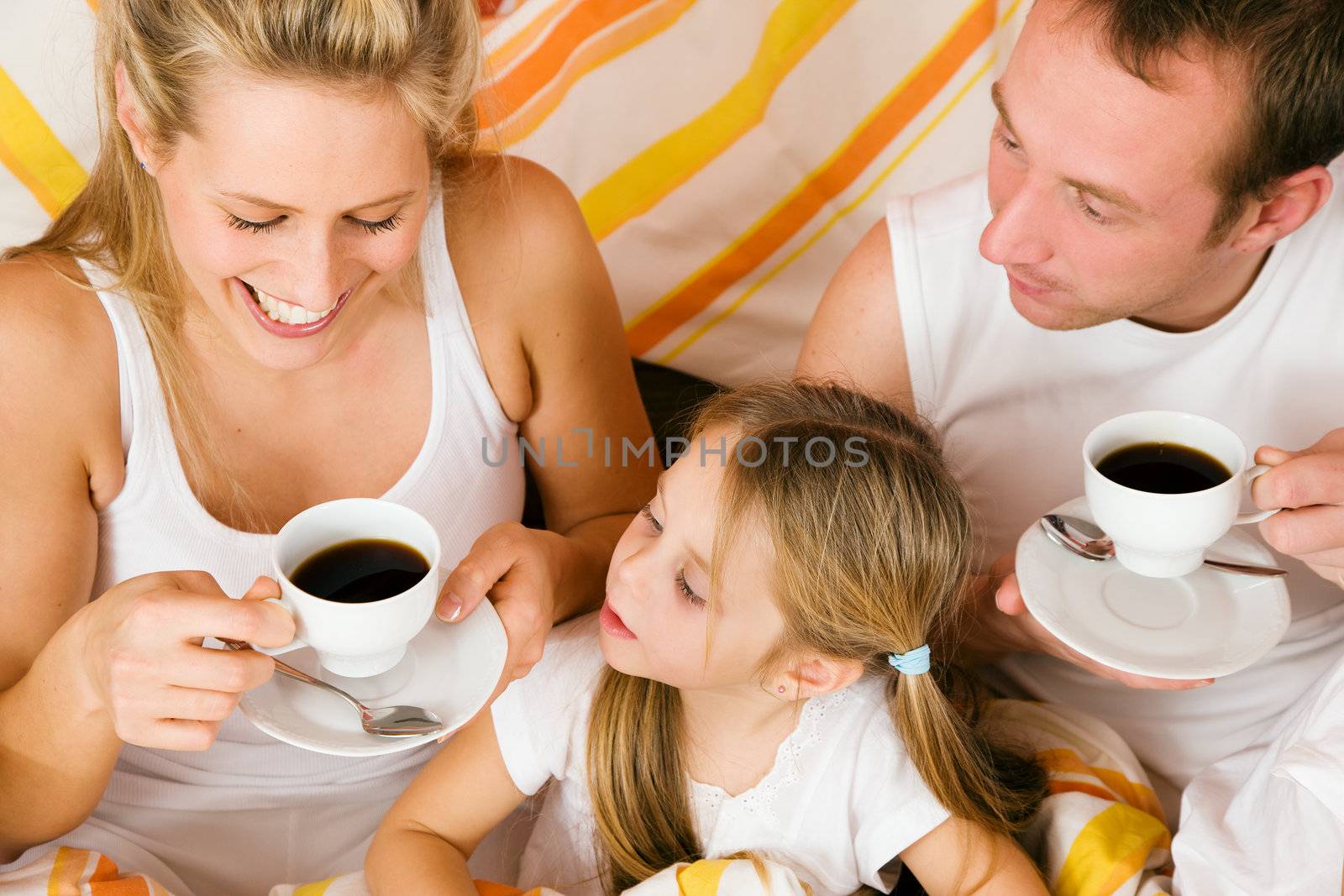 Family having breakfast in their bed in the morning