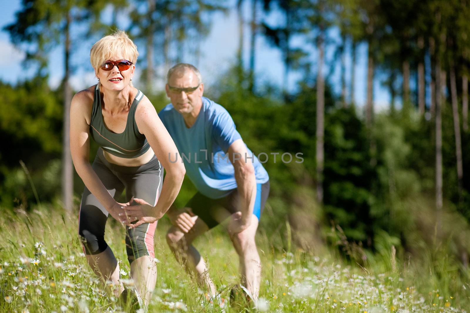 Mature couple doing sport outdoors by Kzenon