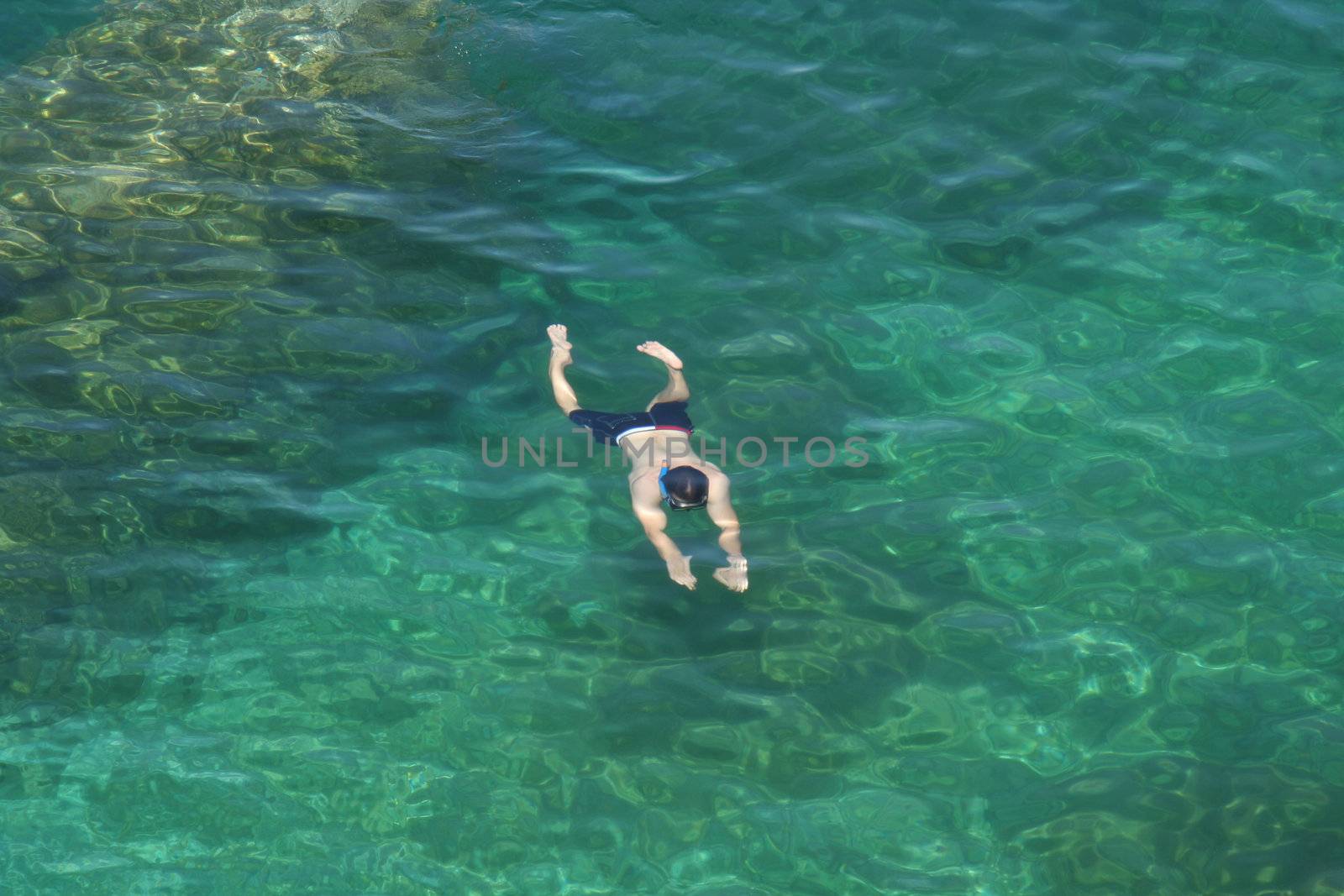 A man swimming under water in the cool waters of Georgian Bay, Ontario, Canada.
