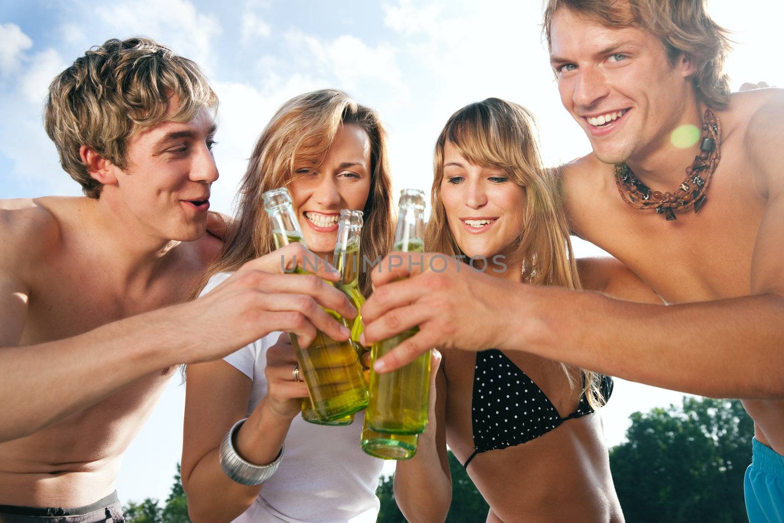 Four people celebrating beach party by Kzenon