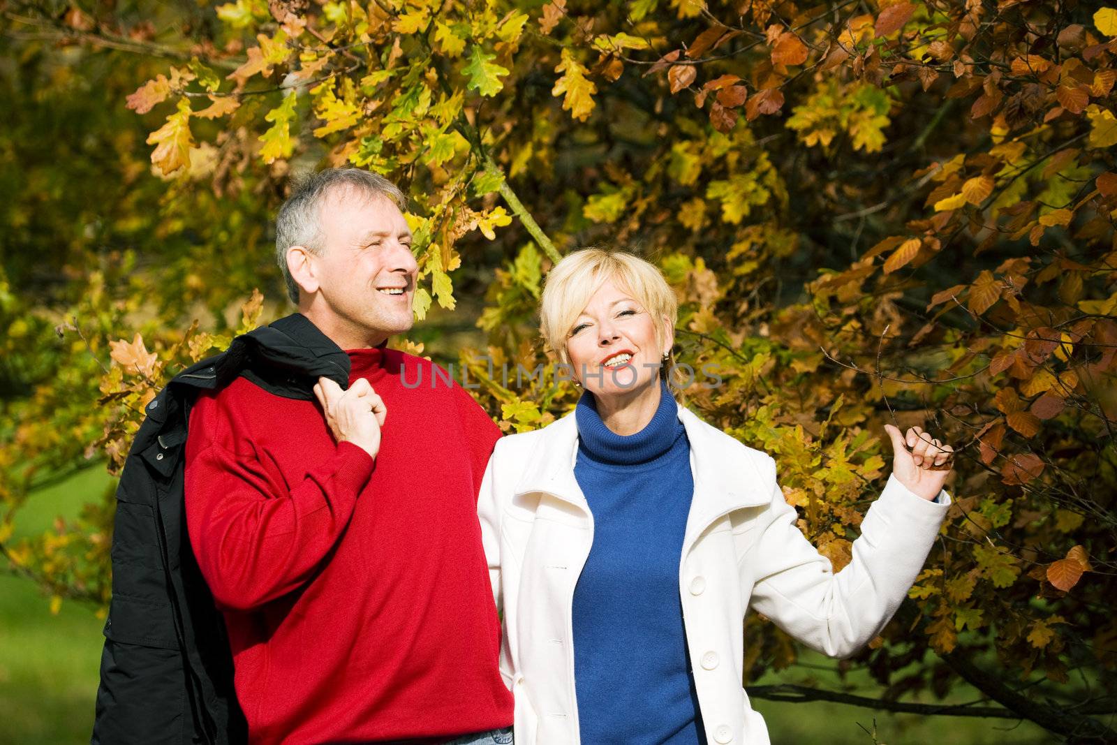 Mature couple deeply in love having a walk holding each other tight