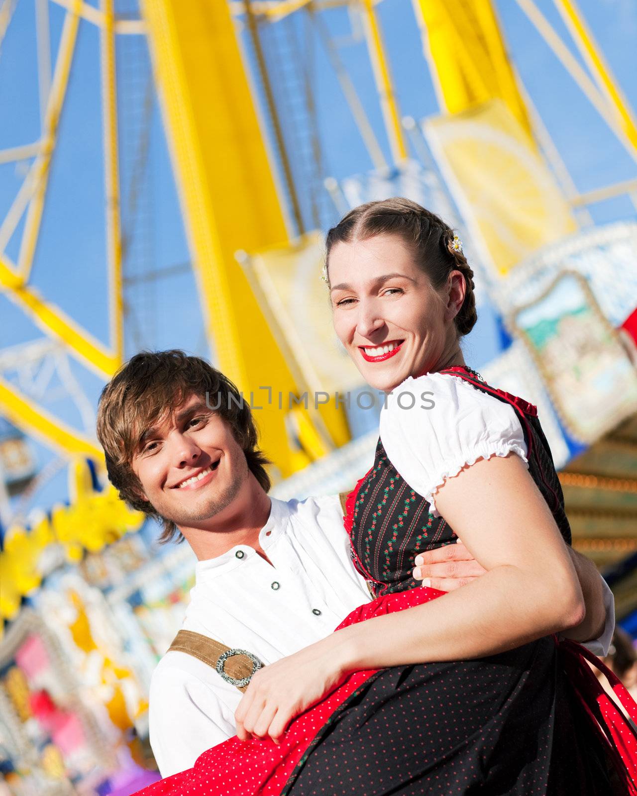 Couple in Tracht flirting at big wheel by Kzenon