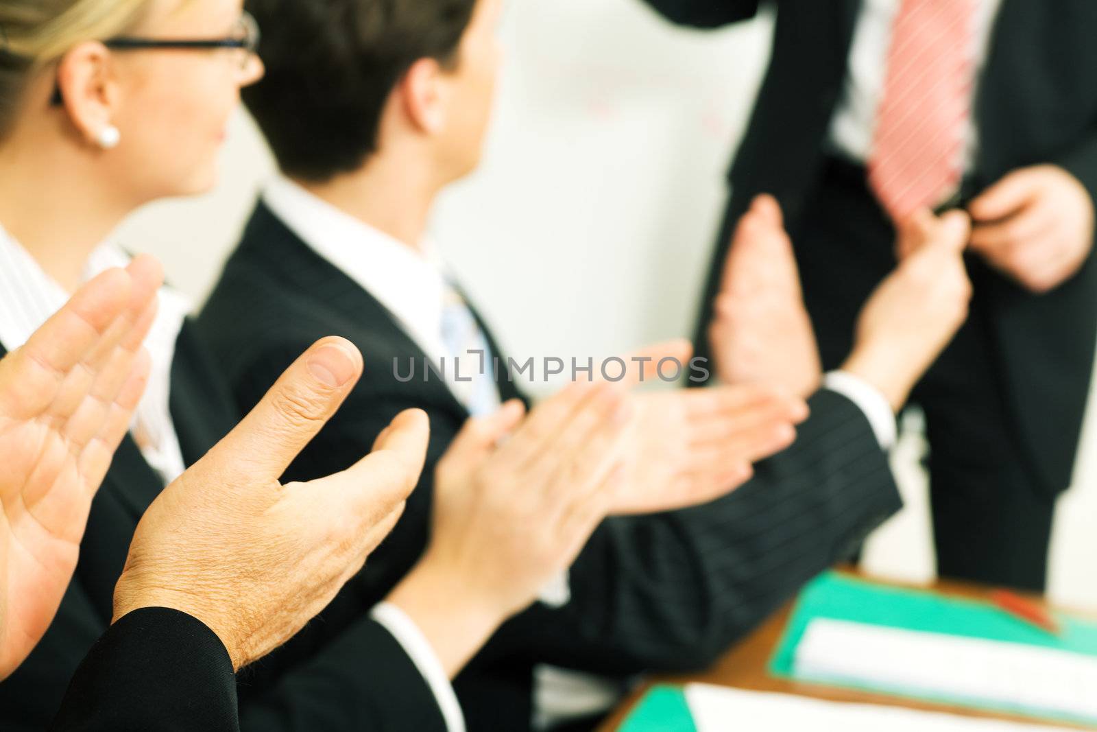 Business team applauding after a successful business presentation (selective focus only on hand in front!)