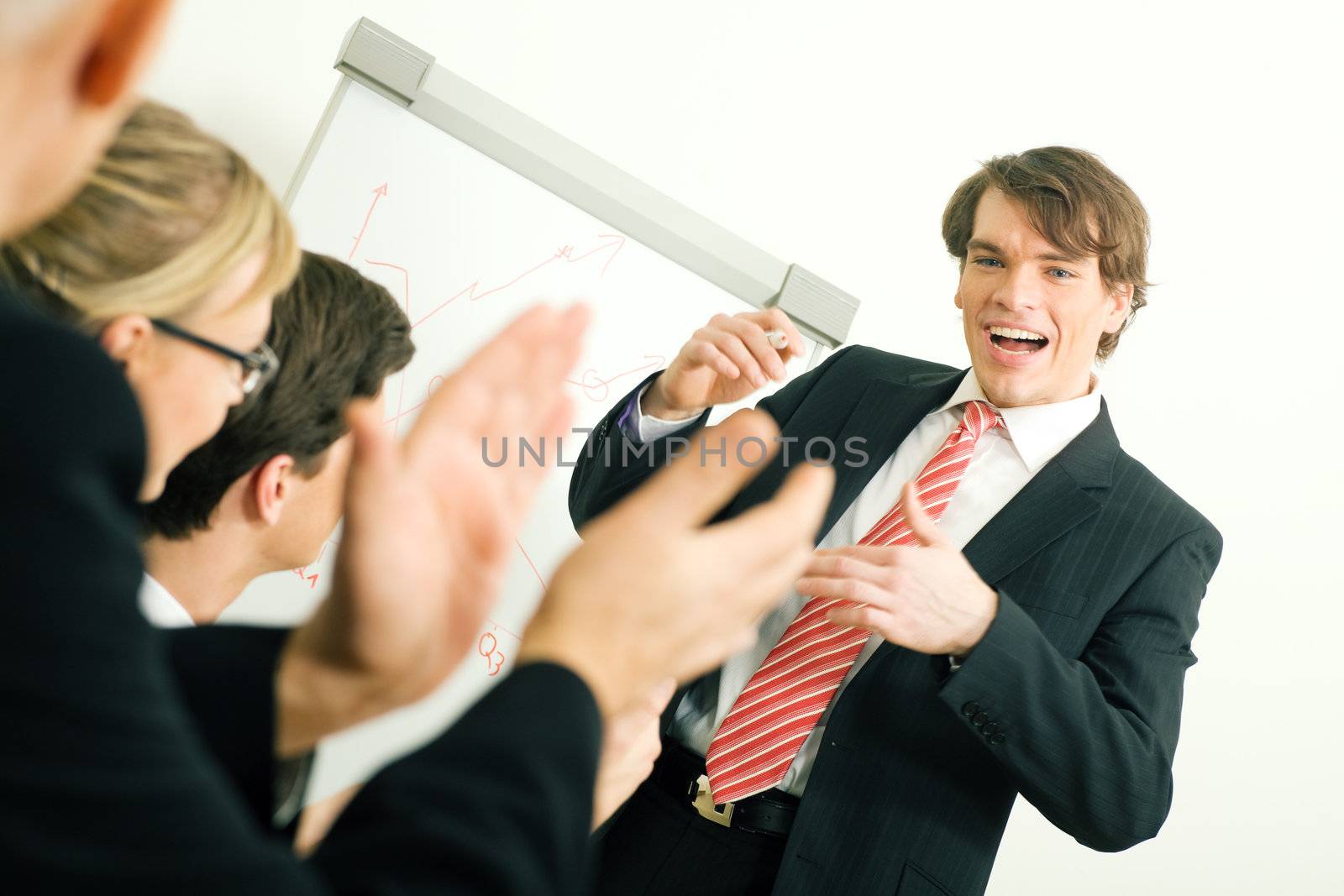 Business team applauding after a successful business presentation (selective focus only on the presenter!)