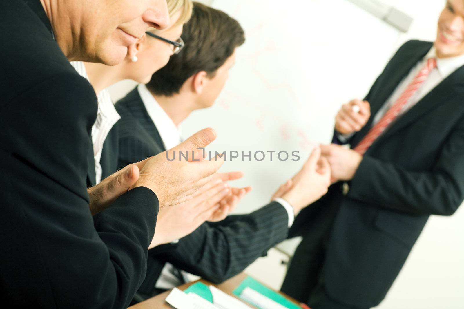 Business team applauding after a successful business presentation (selective focus only on hand in front!)