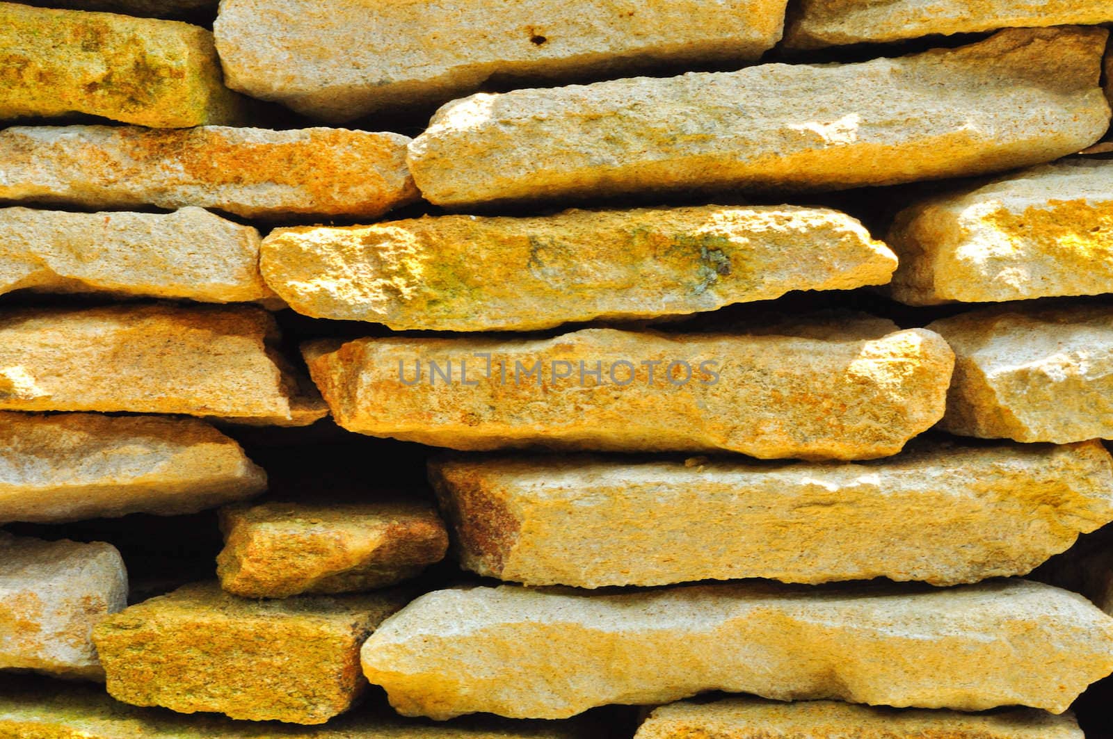 Stacks of large, thick cream and yellowish colored rock slabs 