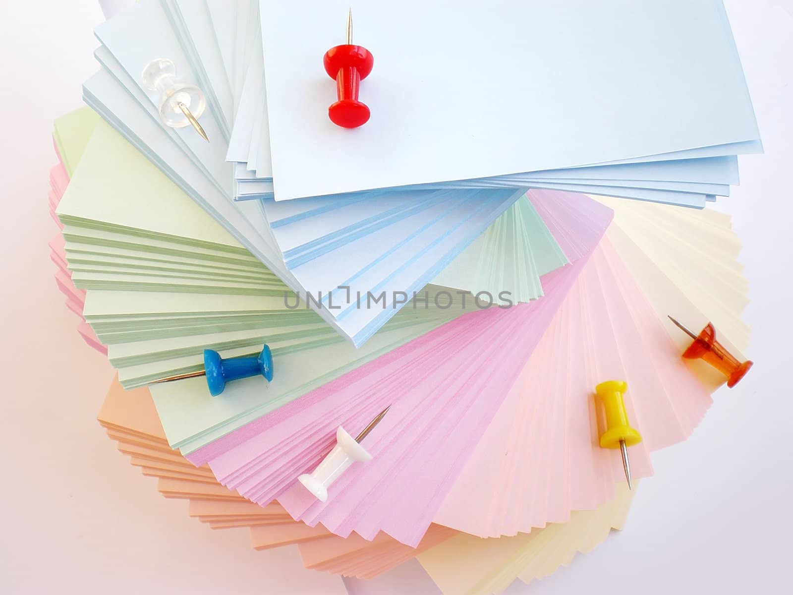 colorful sheets and push pins on white background