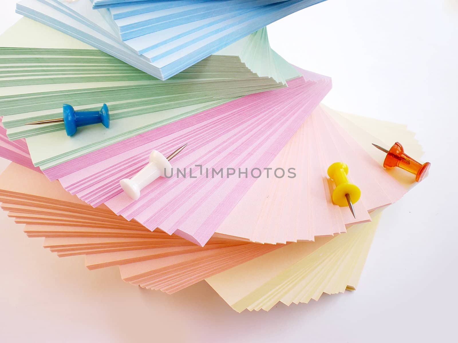 colorful sheets and push pins on white background