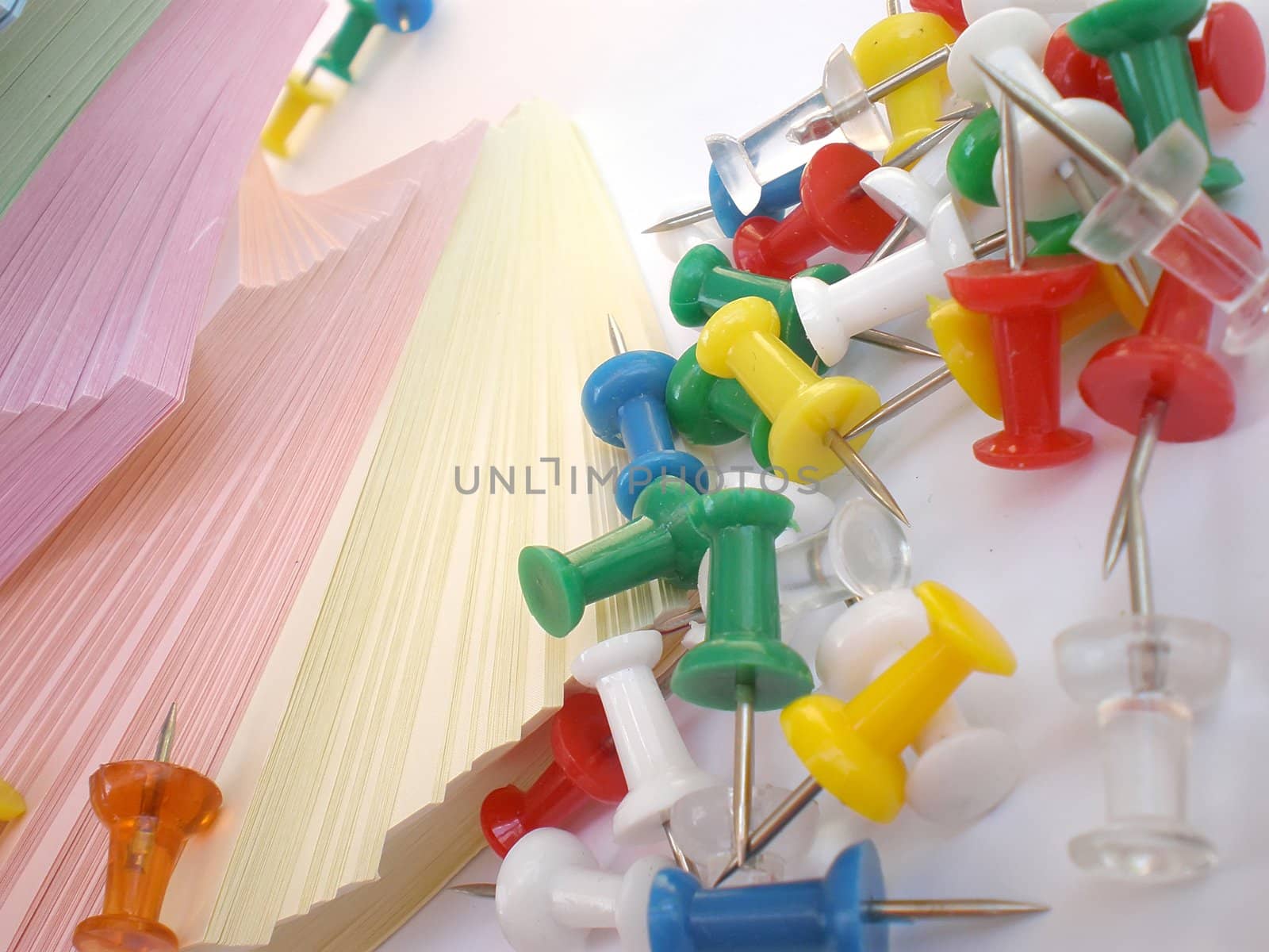 colorful sheets and push pins on white background