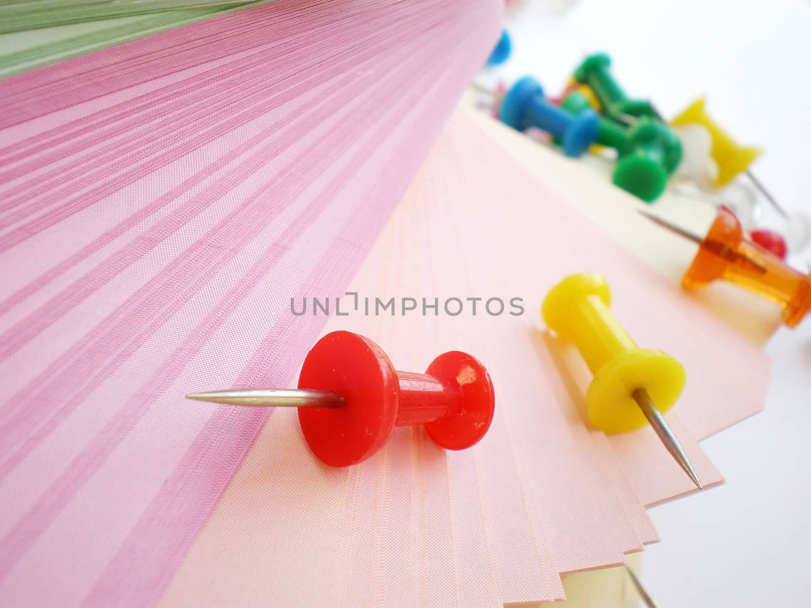 colorful sheets and push pins on white background