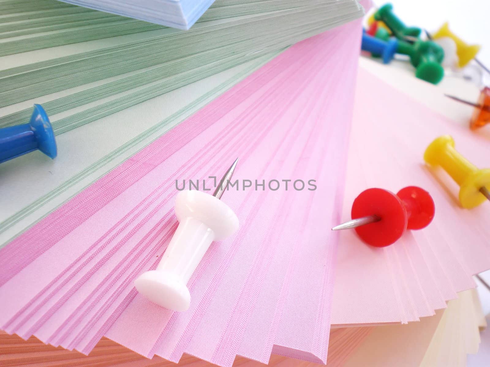 colorful sheets and push pins on white background