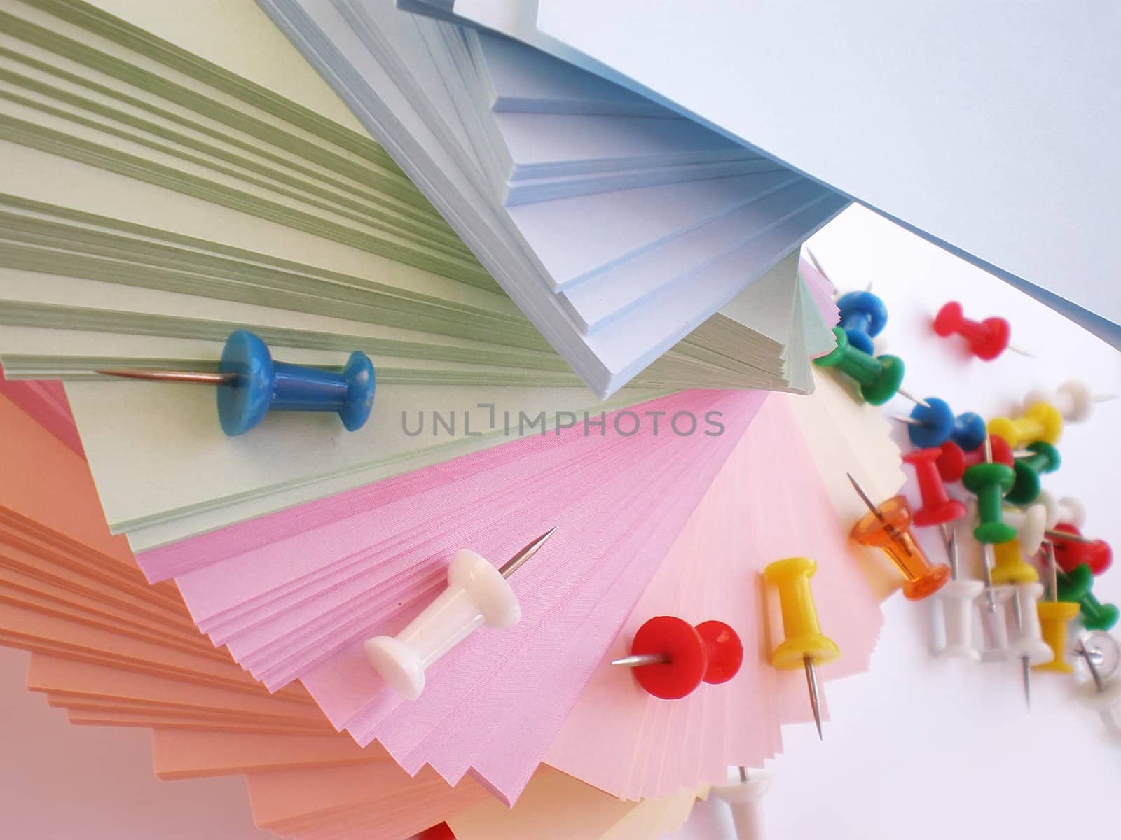 colorful sheets and push pins on white background