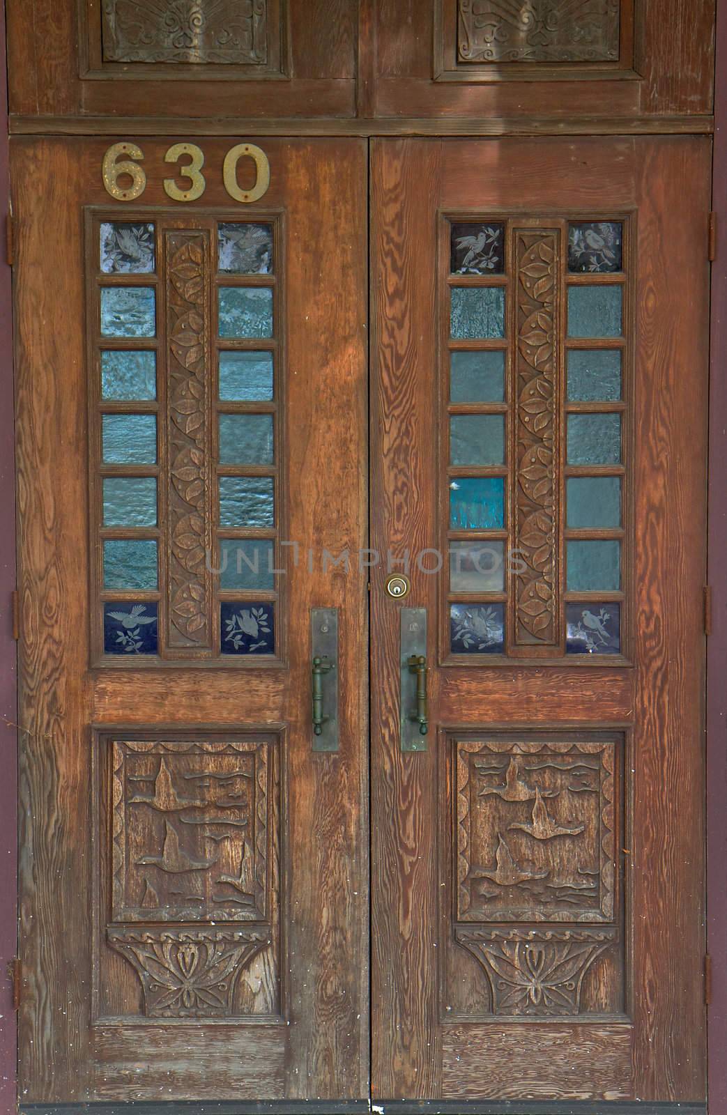 Old worn and weathered wood door with duck and bird carvings and etching