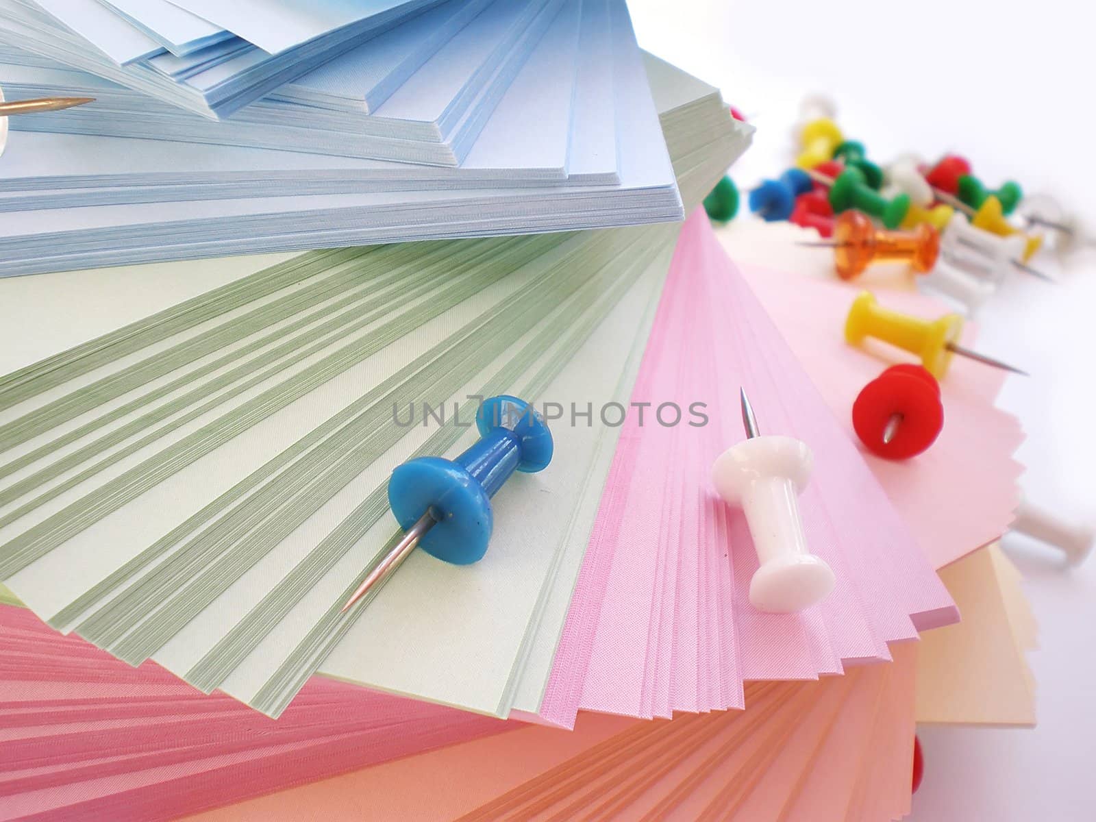 colorful sheets and push pins on white background