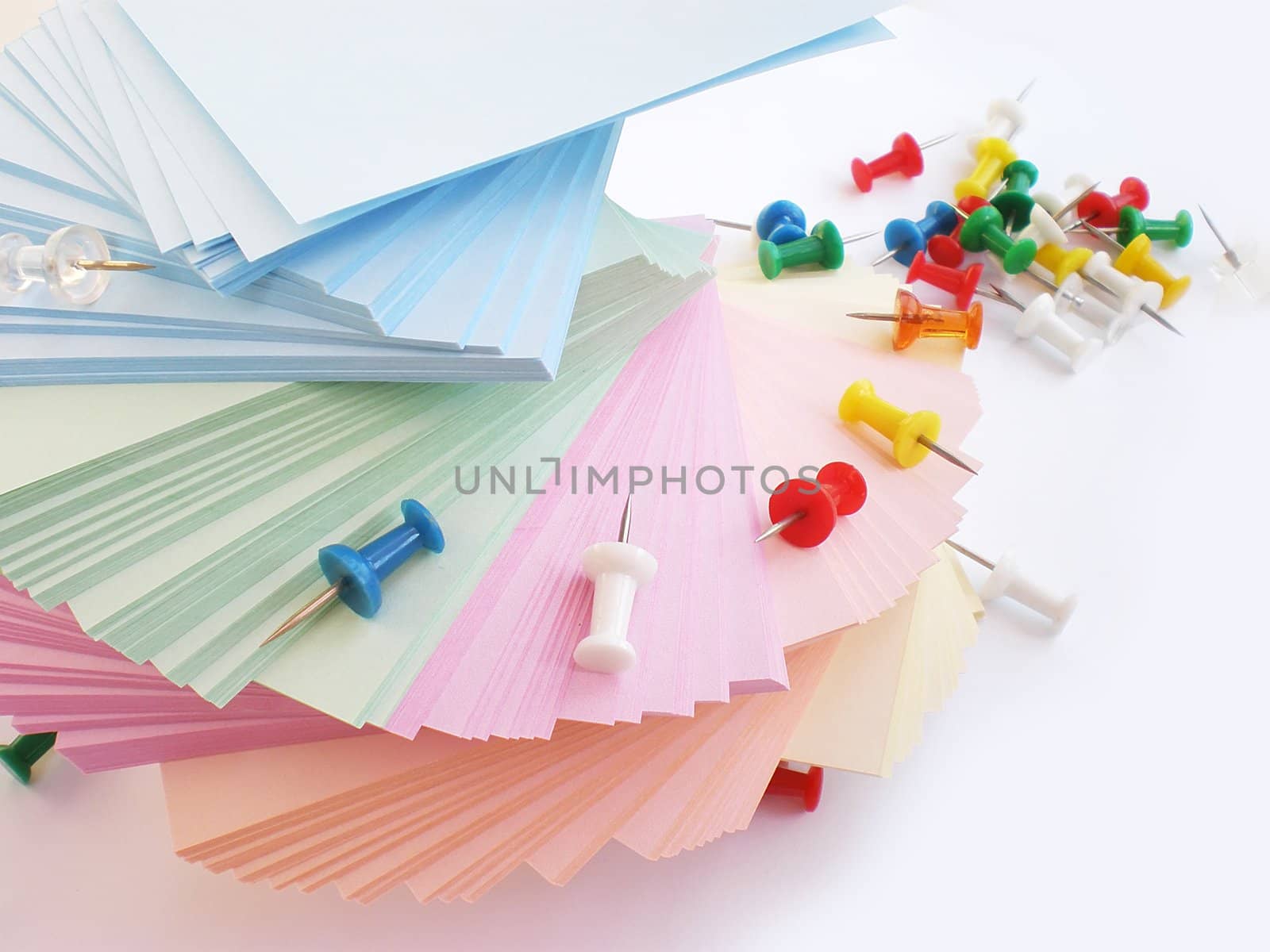 colorful sheets and push pins on white background