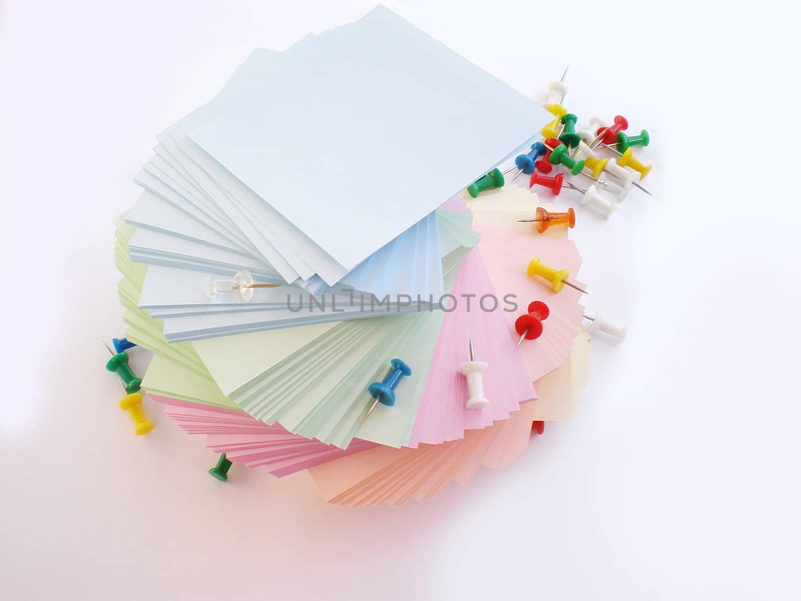 colorful sheets and push pins on white background