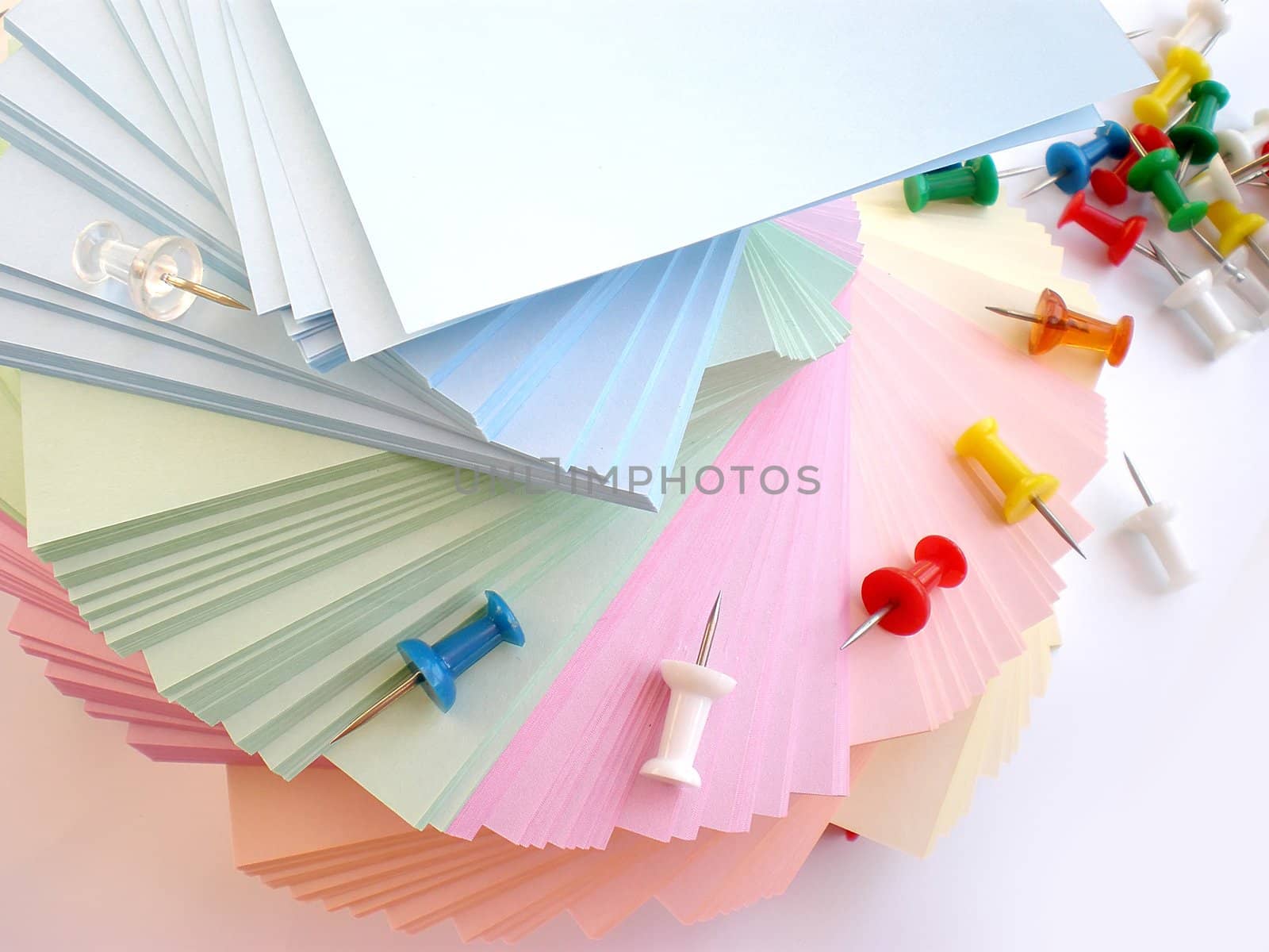 colorful sheets and push pins on white background