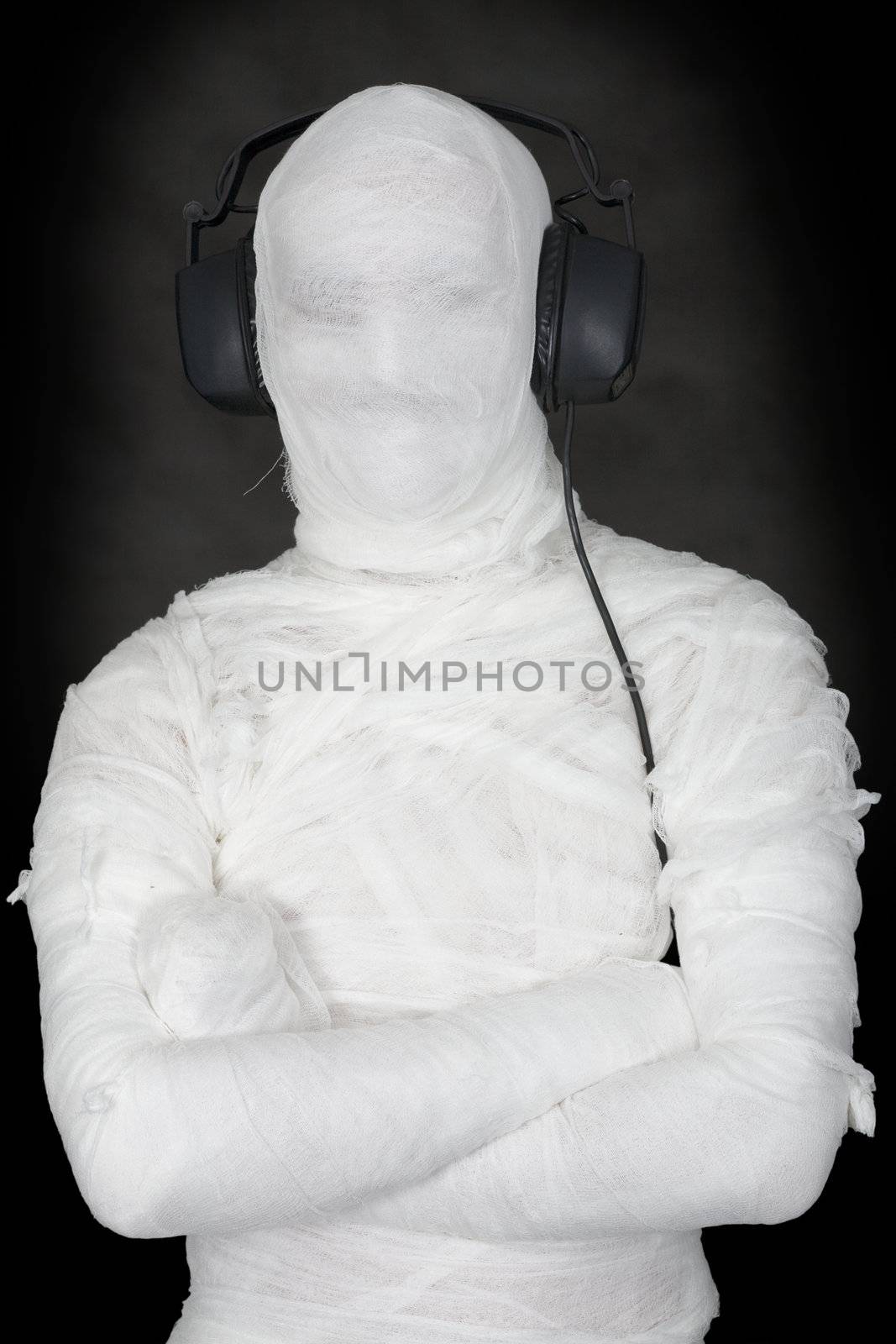 Mummy in ear-phones on black background