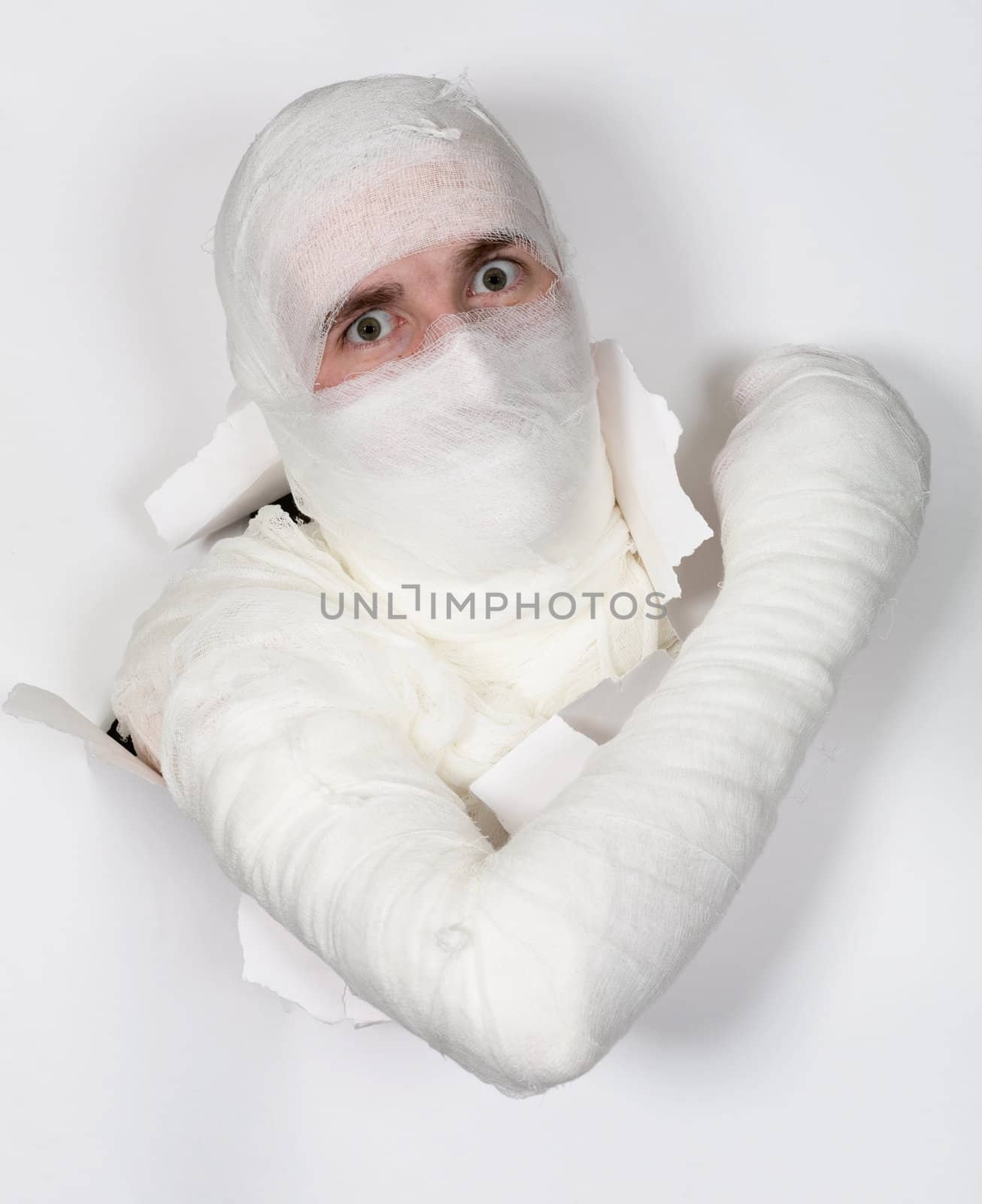 Boy in bandage put out from hole in white paper