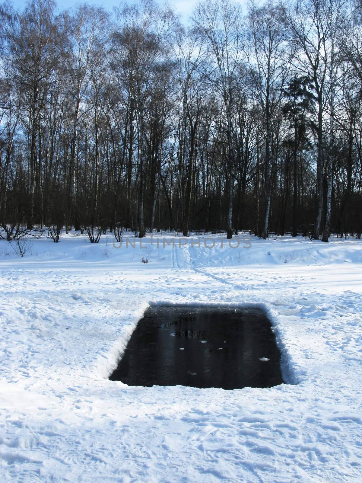 Square ice hole in frozen pond, Moscow winter park