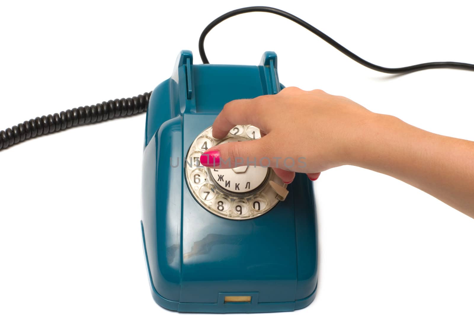 Ladies hand dials the number on the old phone isolated on a white background.