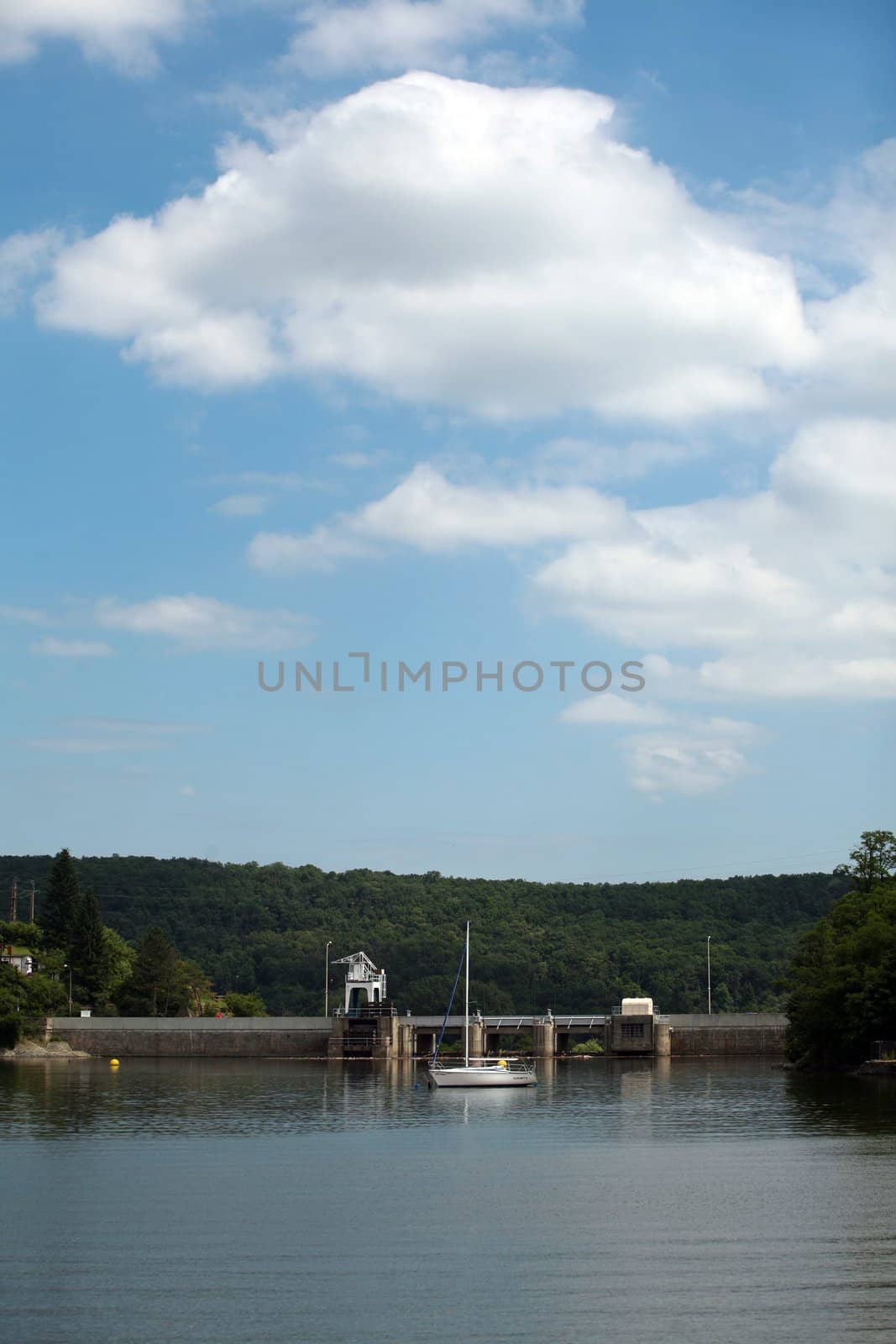 Lake and blue cloudy sky with  houses on the edge