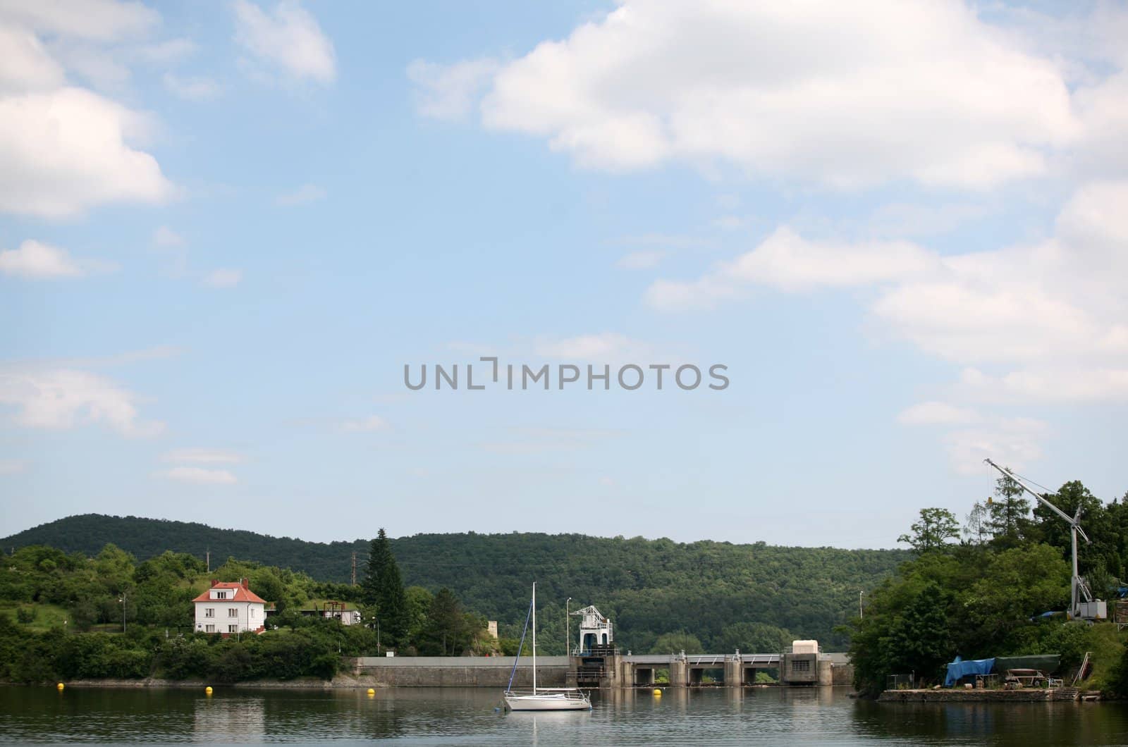 Lake and blue cloudy sky with mole and boat