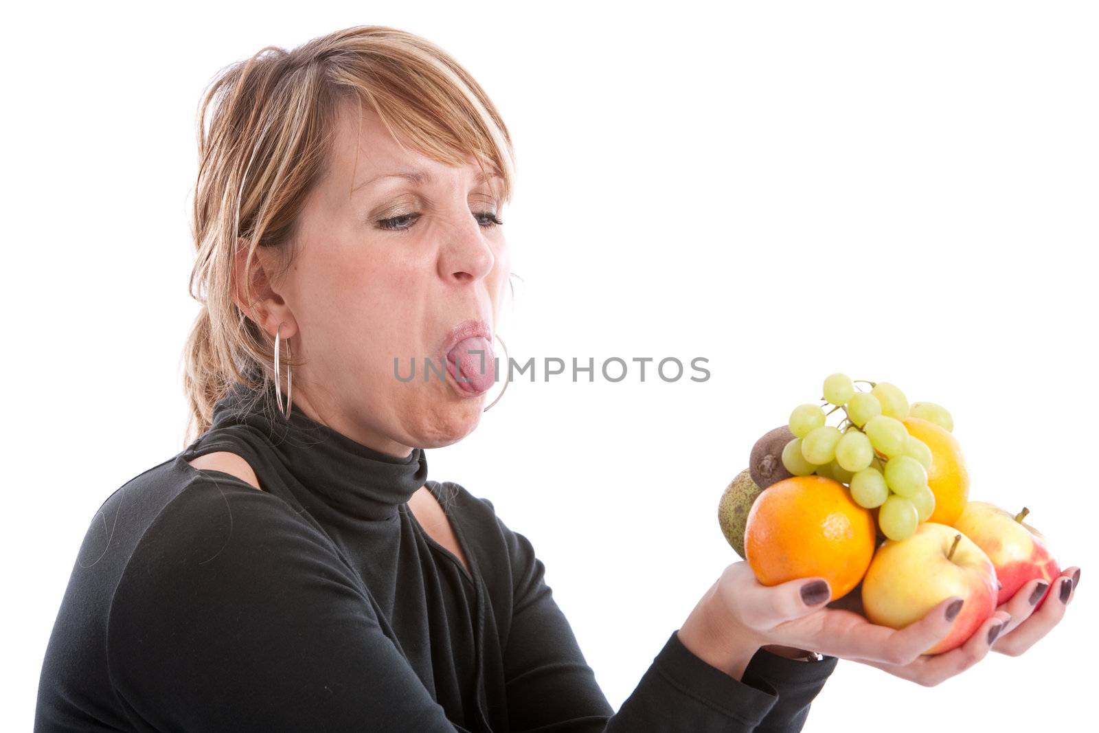 Woman sticking out her tongue to a bunch of fruit in her hands