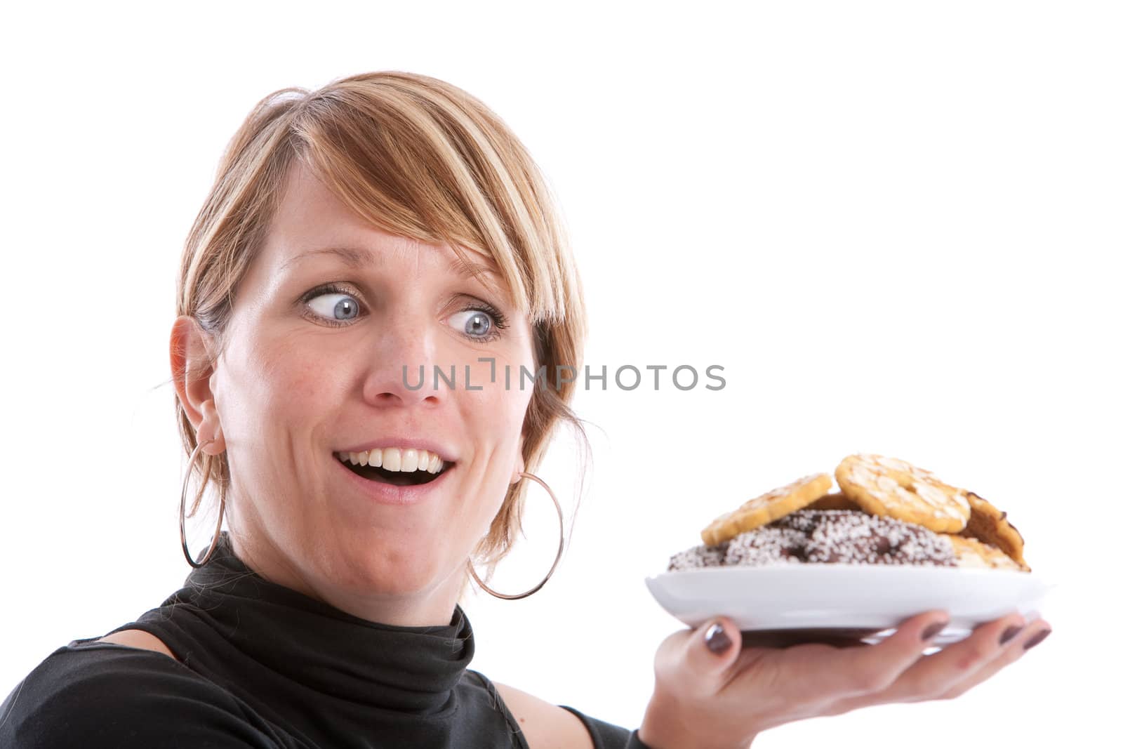 Pretty blond girl looking with excitement at a plate full of cookies