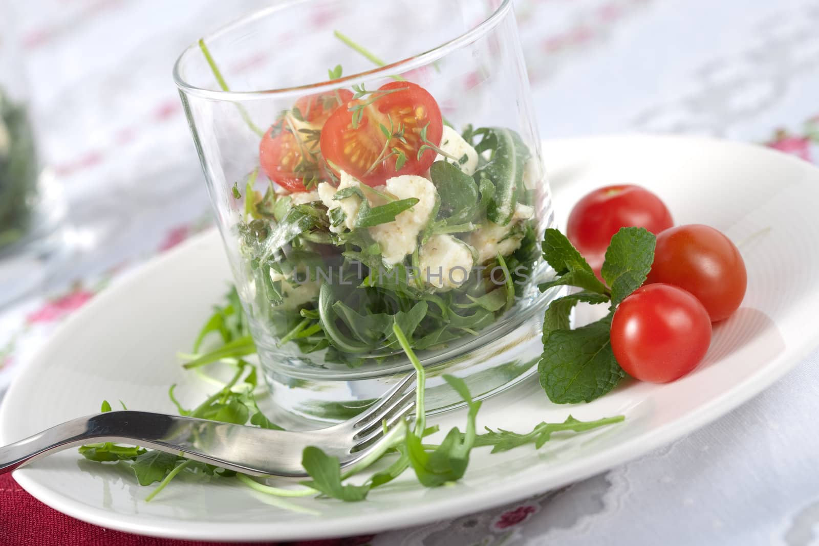 Small salad with feta and mozarella served in a glass