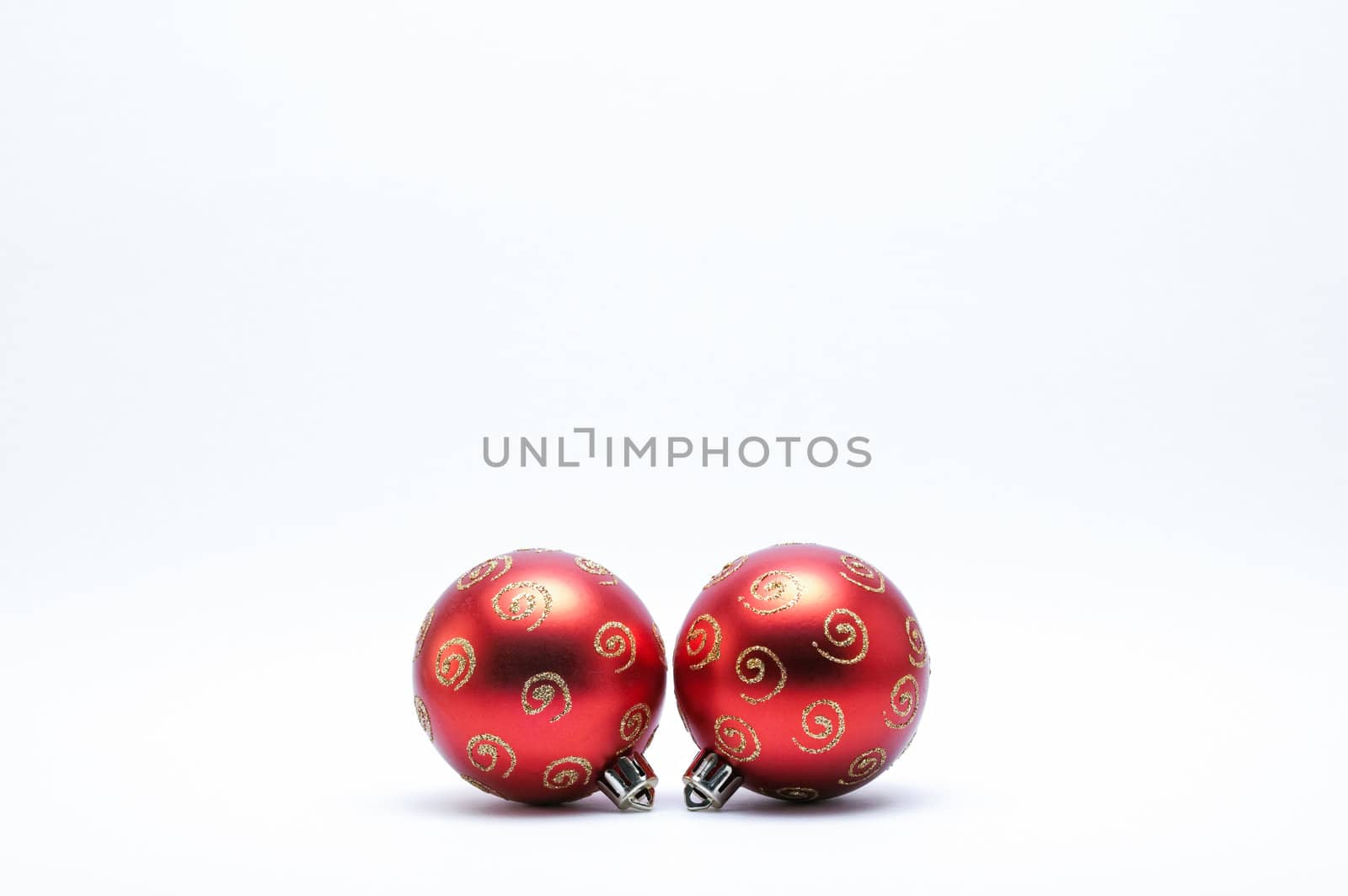 Red Christmas Baubles with gold glitter on a white background.
