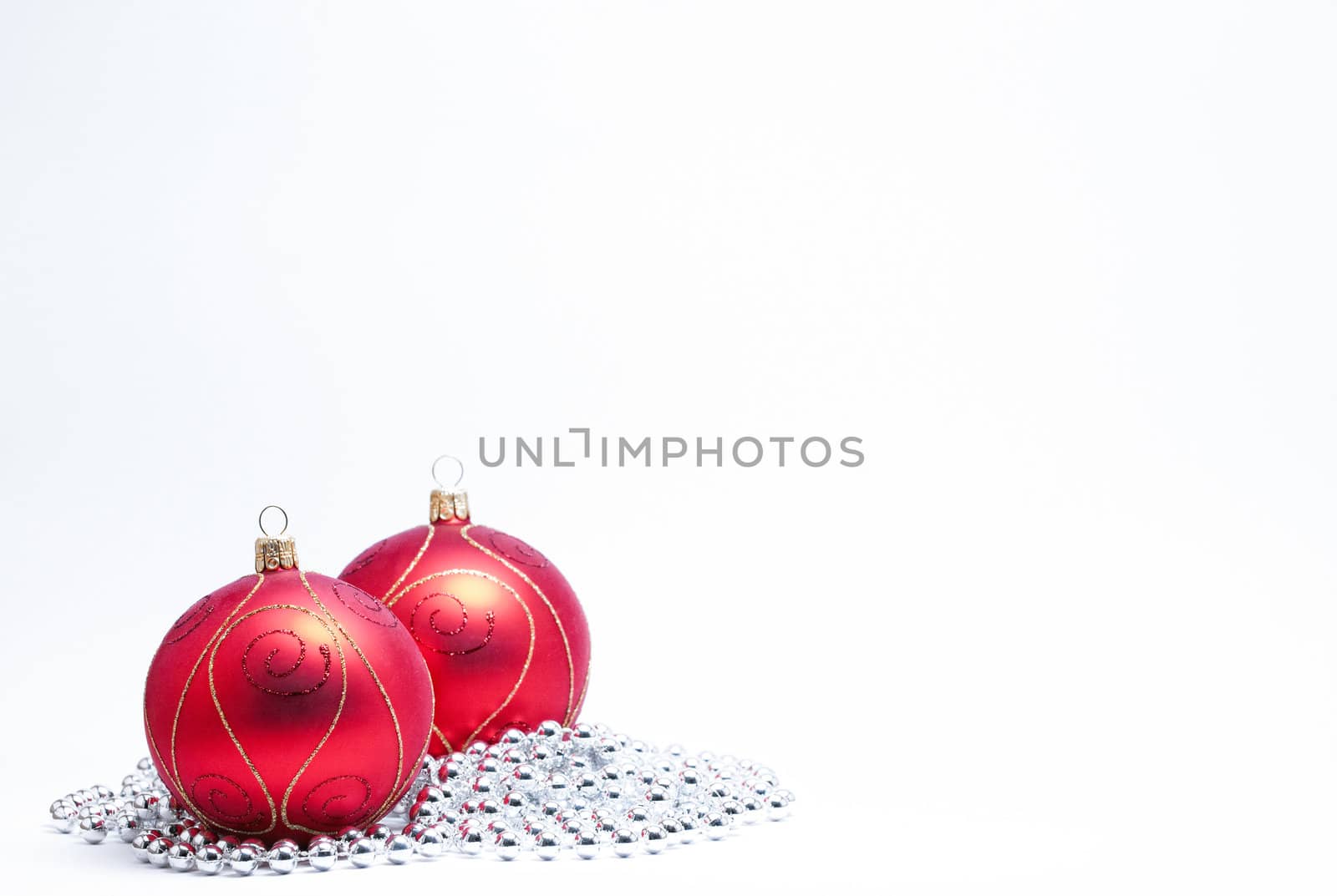 Red Christmas Baubles with gold glitter and silver beads on a white background. (Selective Focus)