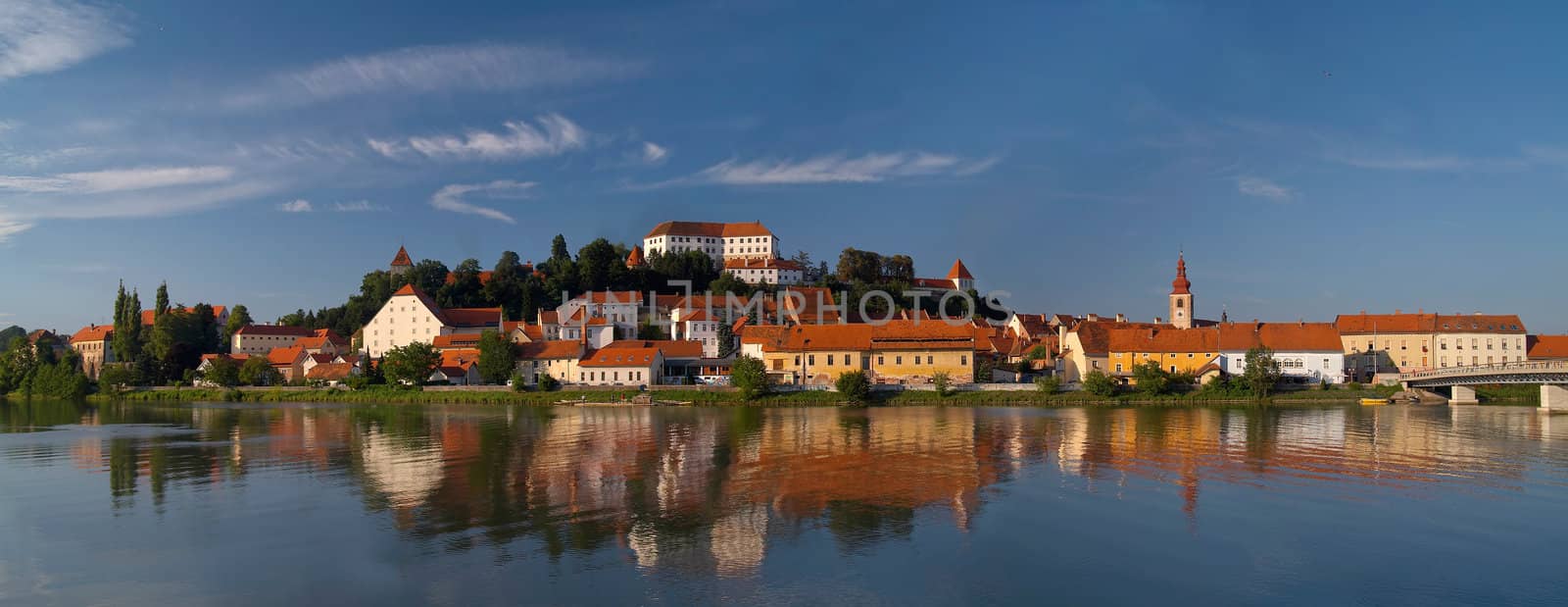 Old city Ptuj with castle and a reflection in river Drava.