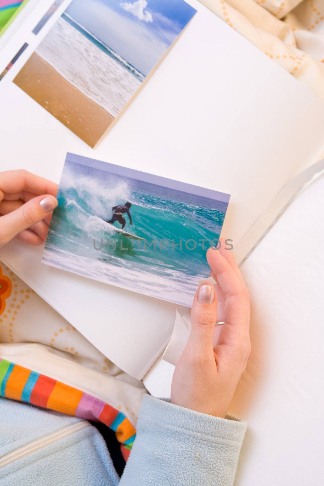 Woman hands sticking images in her photo album. Images can be replaced.