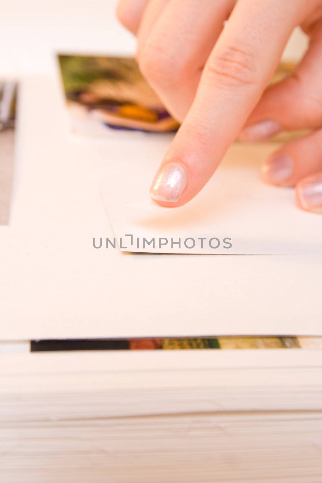 Woman hands sticking images in her photo album. Images can be replaced.