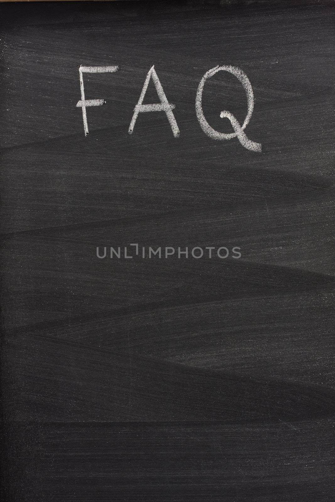FAQ - frequently asked questions title handritten with white chalk on a blackboard with strong eraser pattern