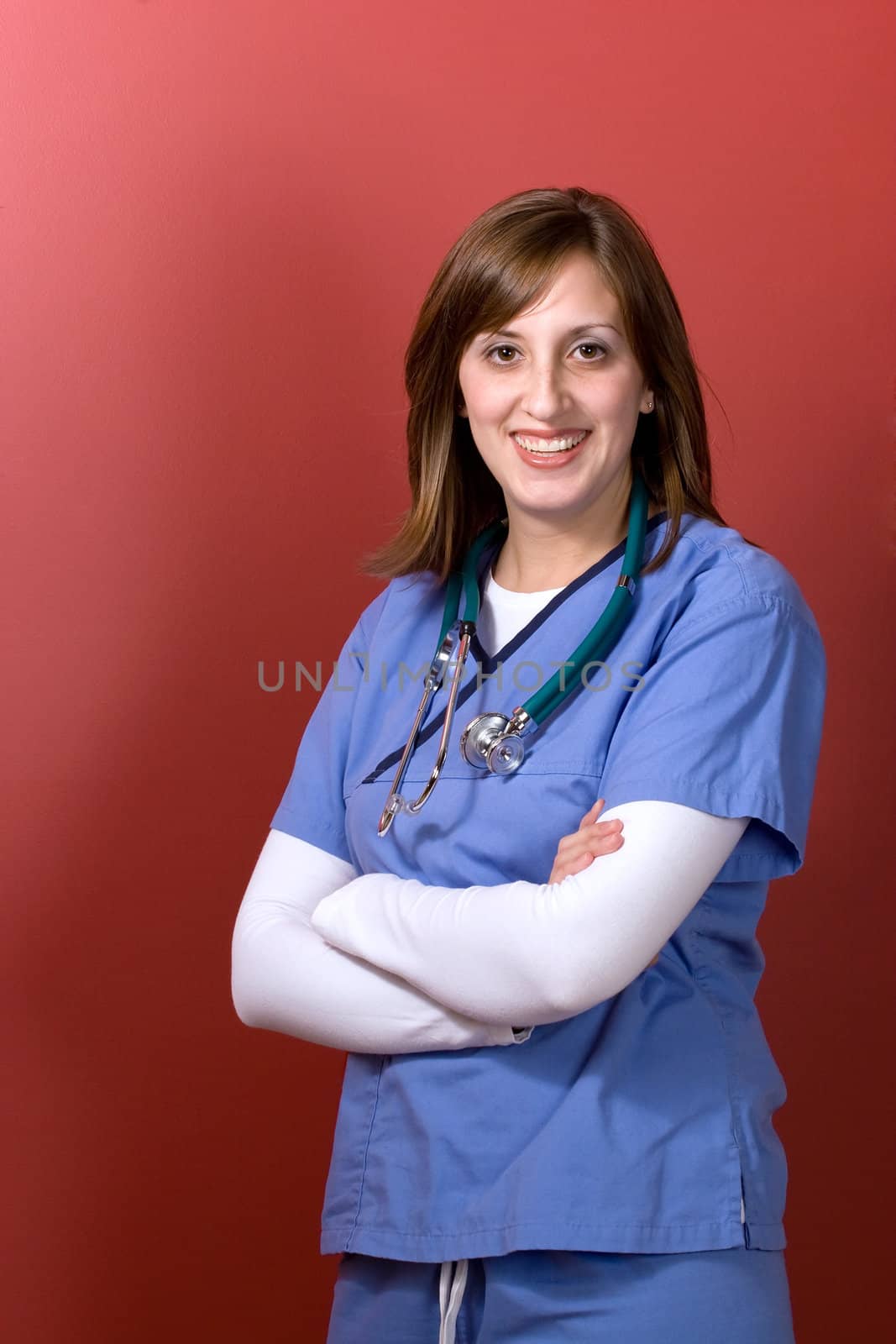 A young woman doctor with her arms crossed isolated over a red background