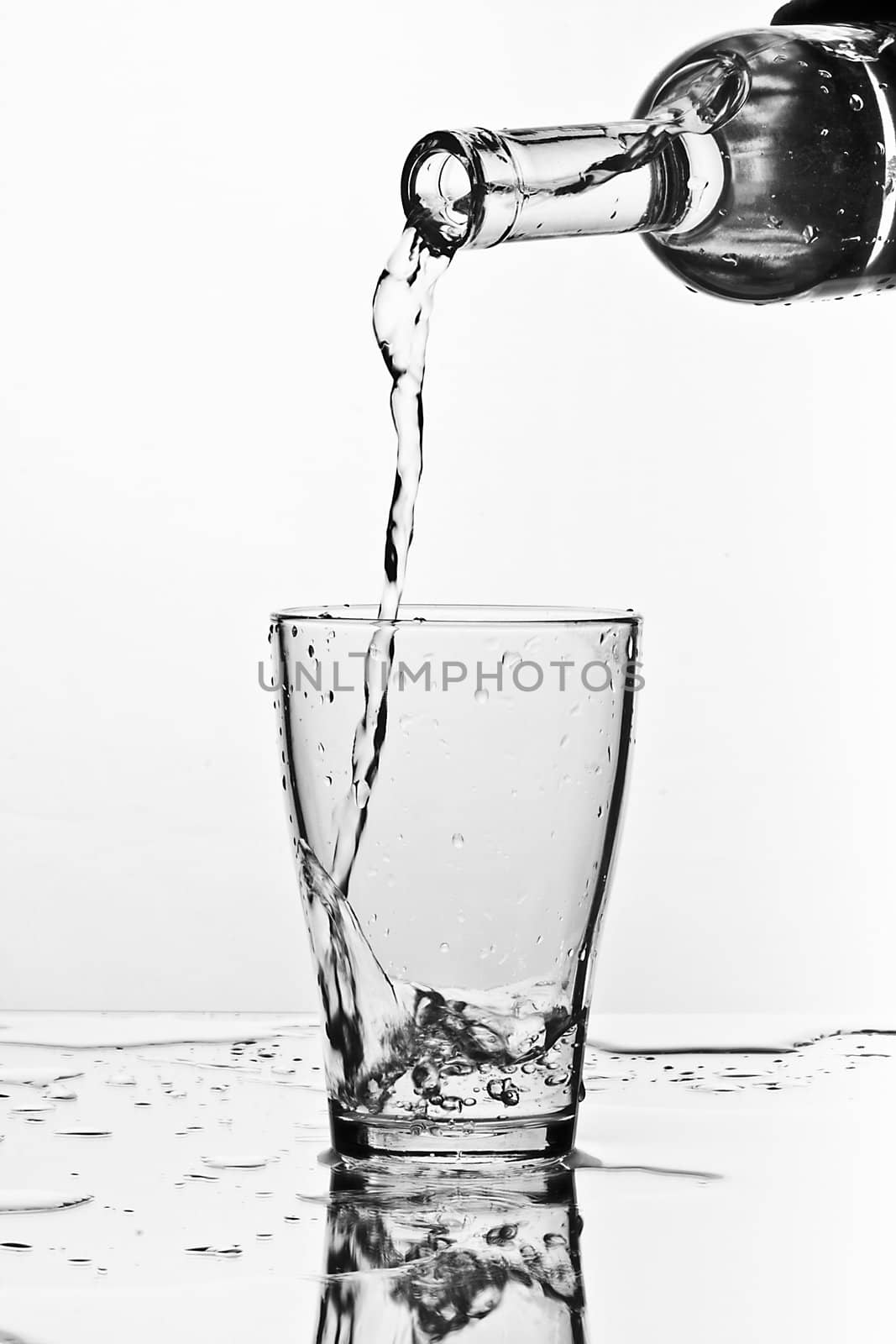 glass of pouring water with reflection (white background)
