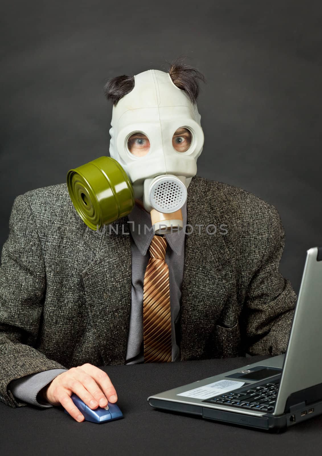 The amusing person has dressed a gas mask and works with the computer