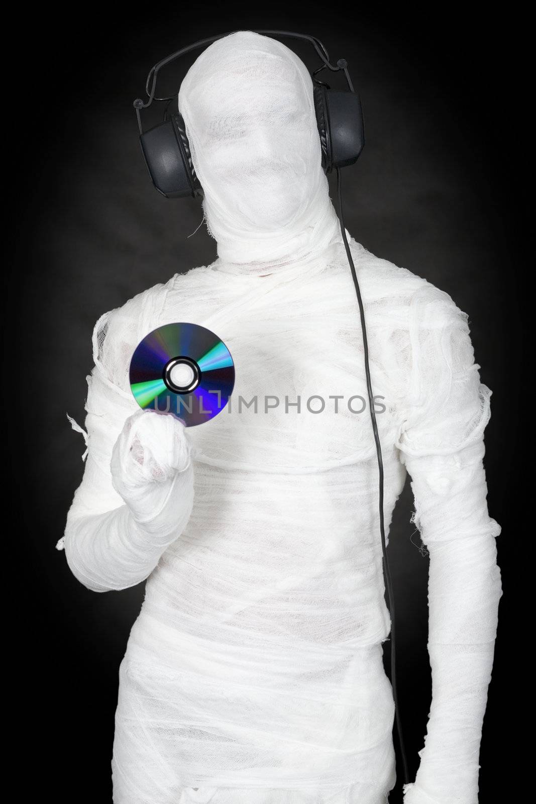 Man in bandage with ear-phones and disc on black