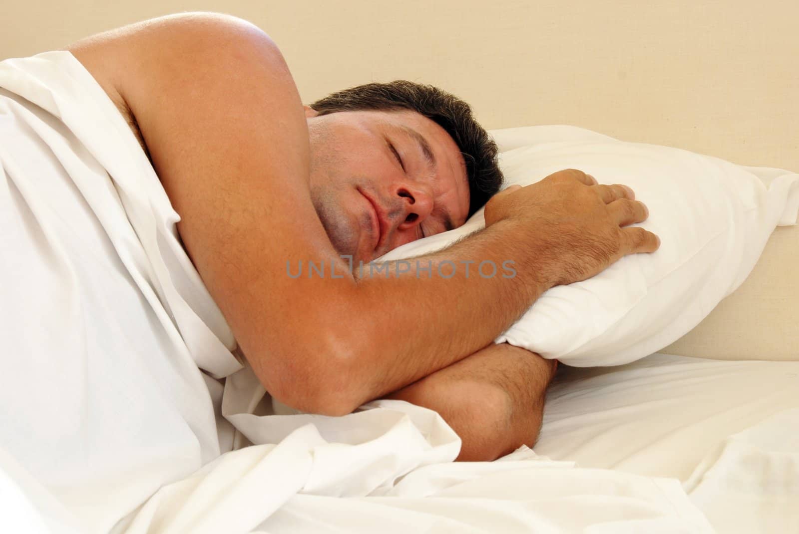 mature man sleeping on white pillow in bed