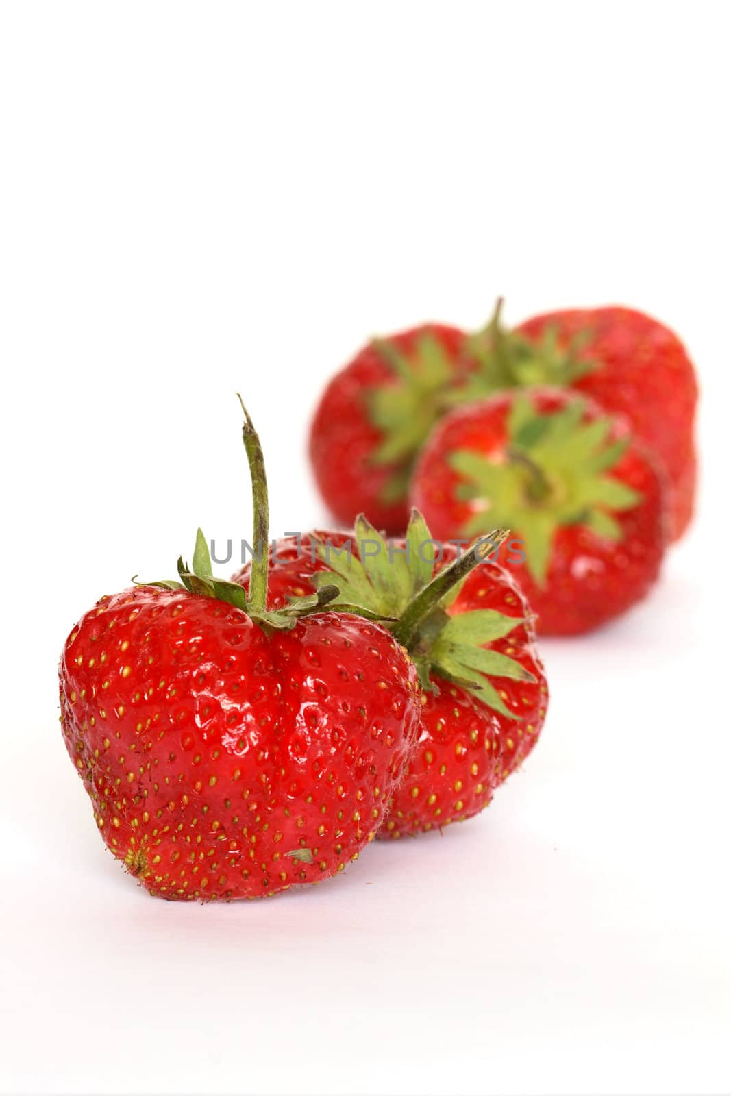 Few red freshness strawberries lying on white background