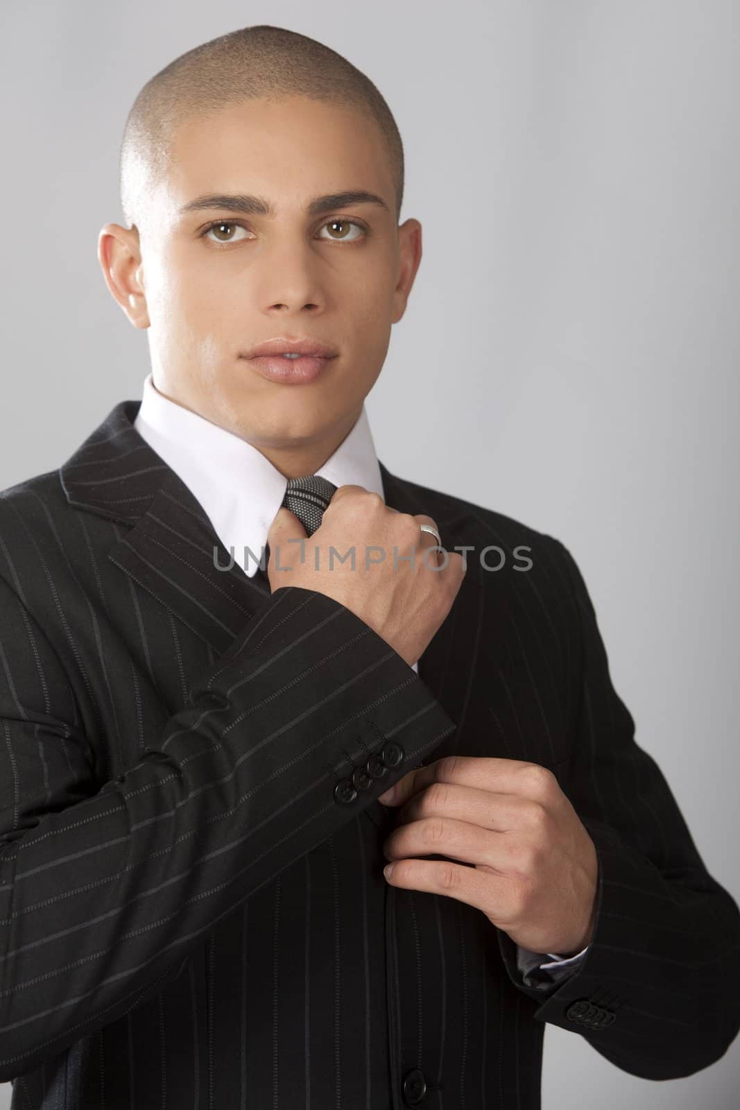 A young good looking businessman on a gray background.