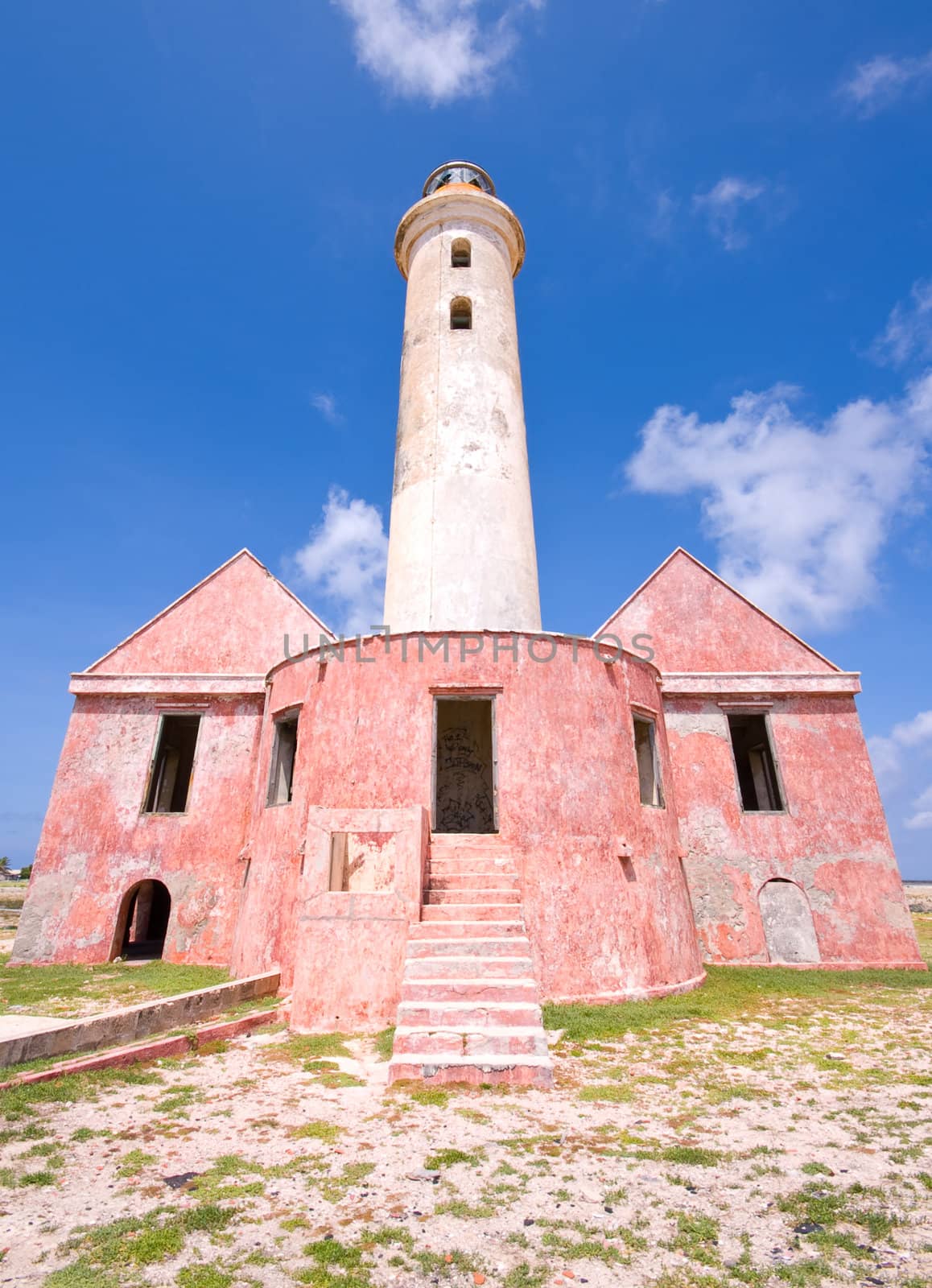 ancient lighthouse ruin on little curacao against blue cloudy sky 
