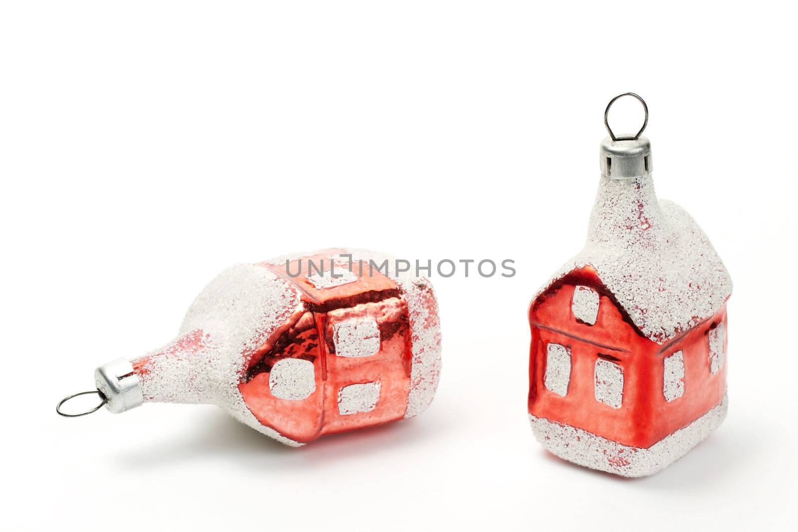 two red house shaped christmas ball ornaments on white background