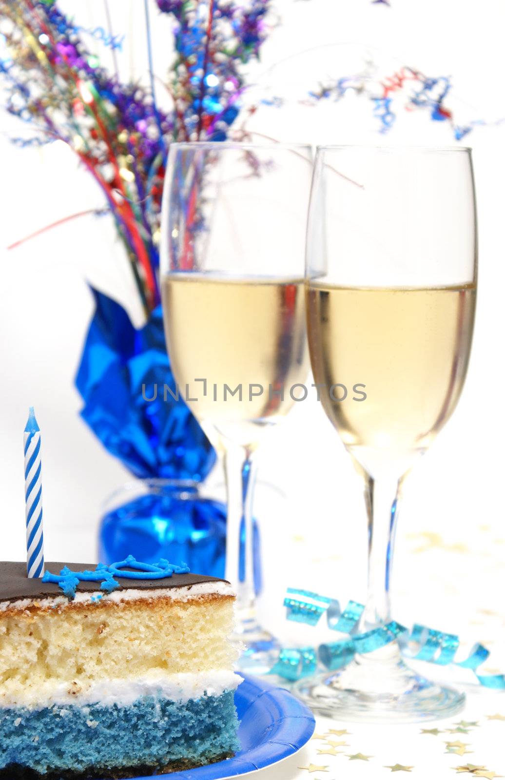 A slice of cake in front of two glasses of champagne.