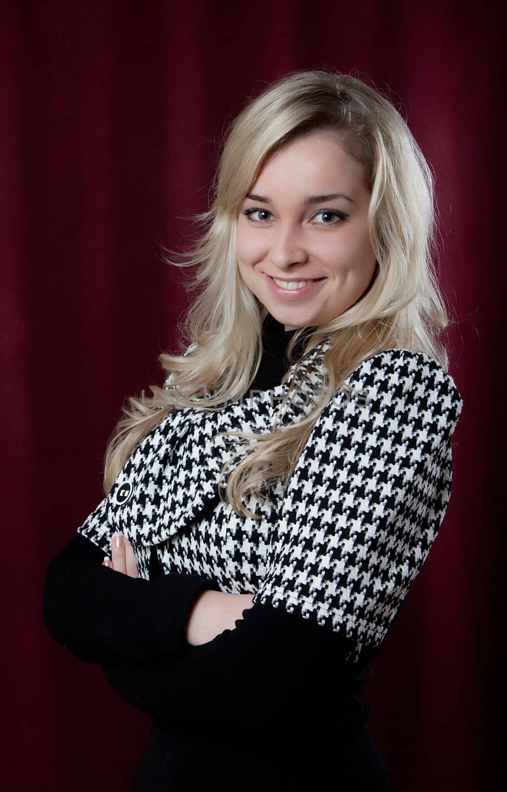 Portrait of the young smiling girl on a dark background