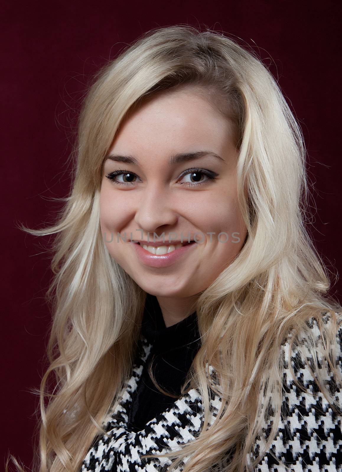 Portrait of the young smiling girl on a dark background