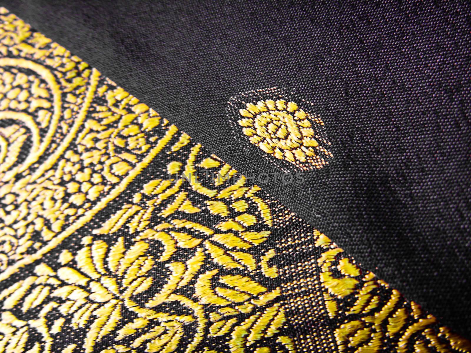 A closeup of a yellow and black traditional indian fabric, known as the sari/saree