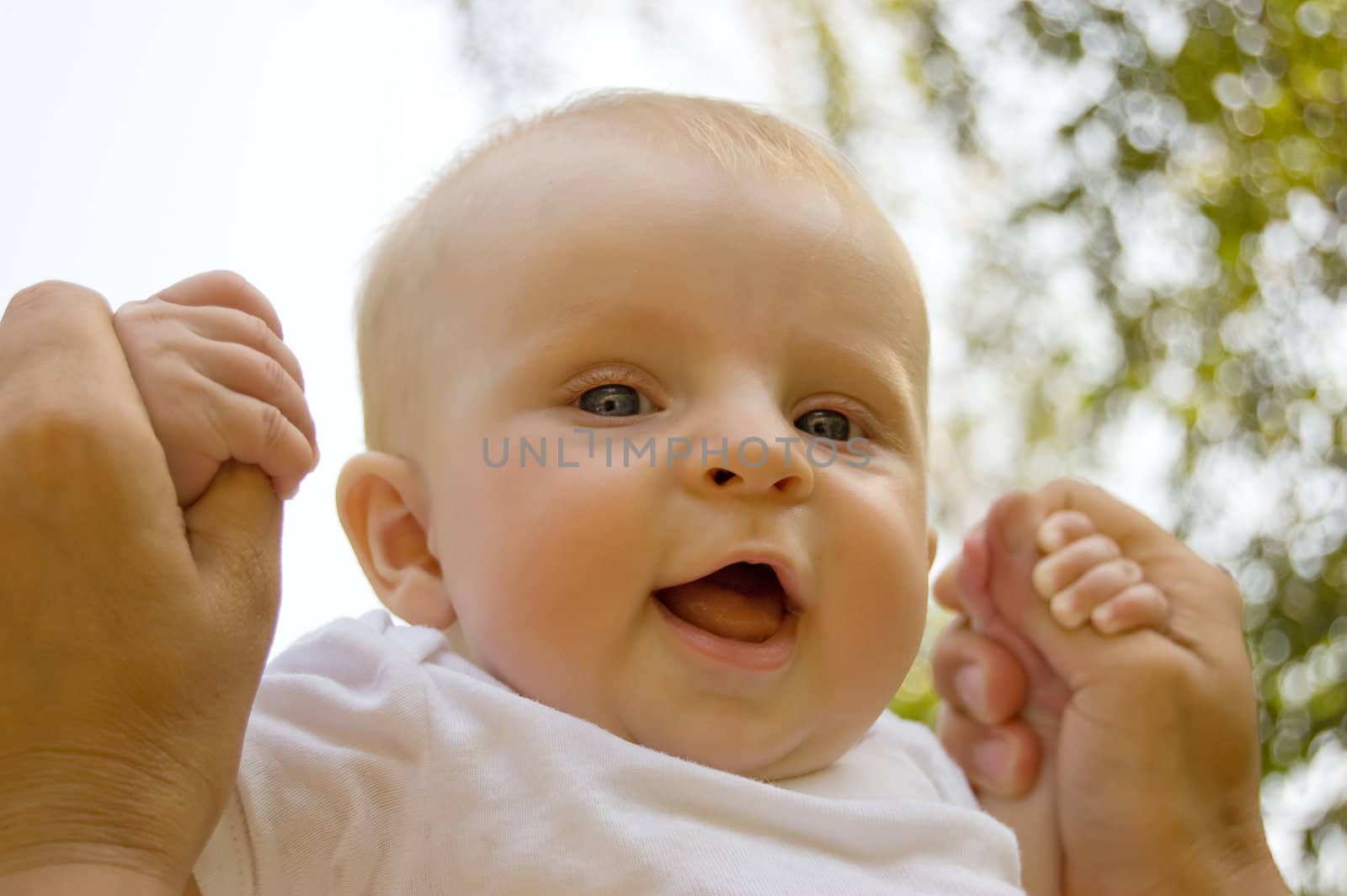 Happy baby face in parent's hands